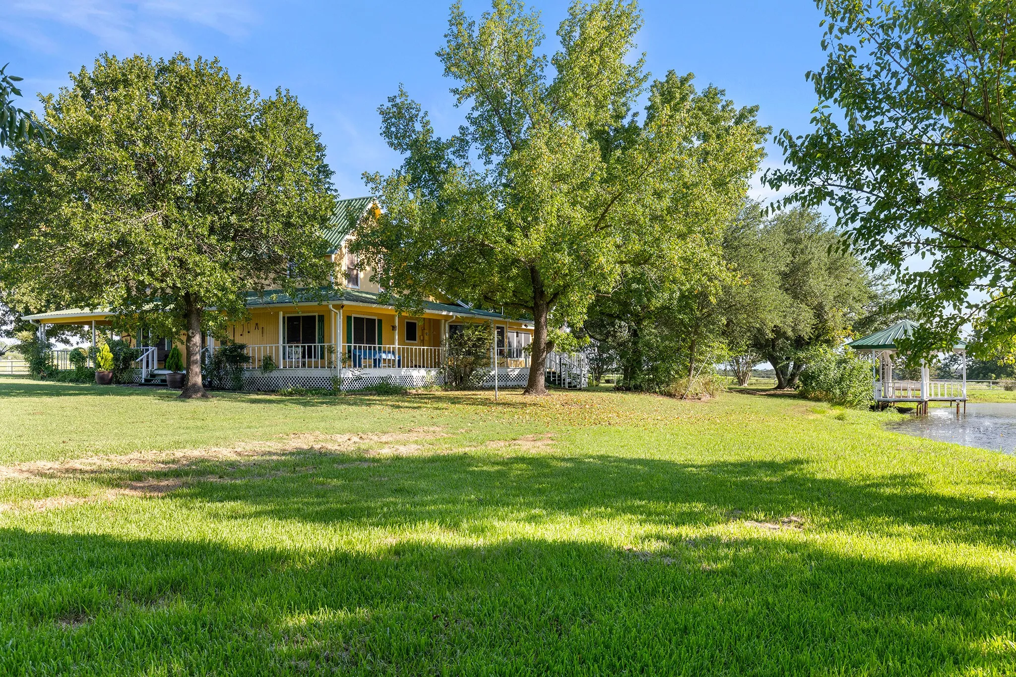 View of grassy yard featuring a large porch and a water view