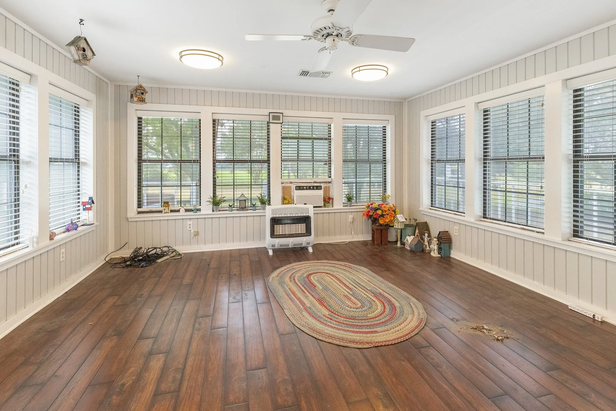 Sunroom featuring plenty of natural light, wood-type flooring, and heating unit