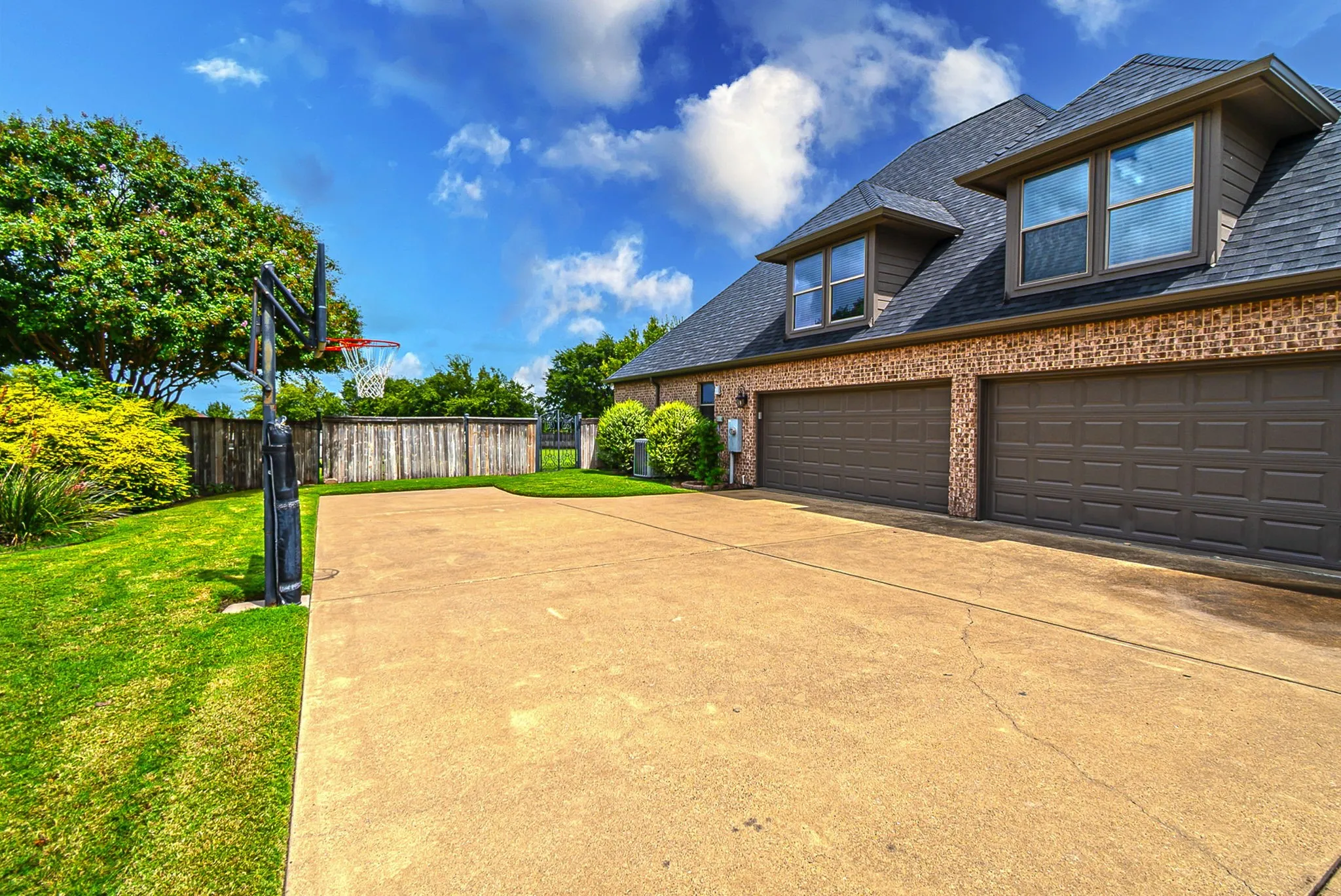 View of 4-car garage, extended driveway.