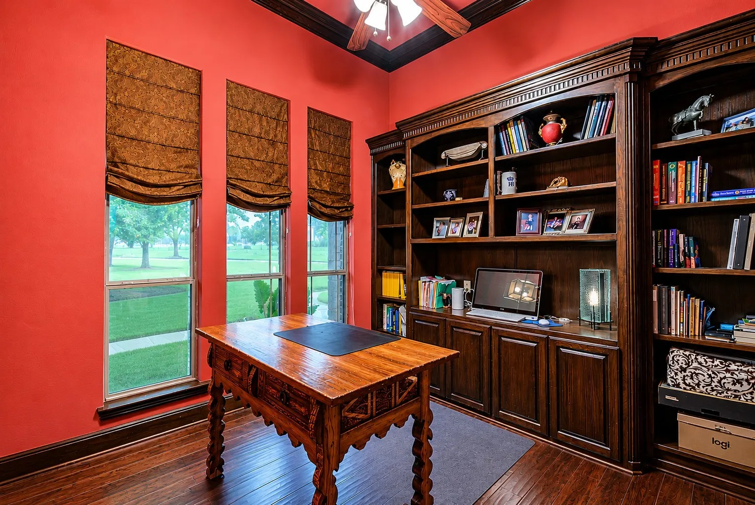 Dedicated office with wood floors and built-in wood shelving.