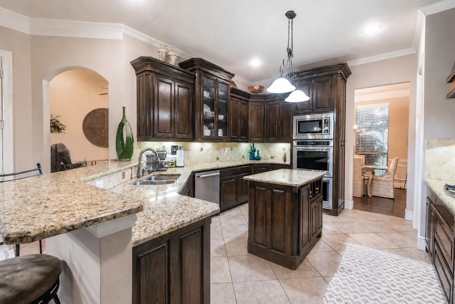 Amazing kitchen with granite countertops, island, gorgeous cabinetry, and double ovens.
