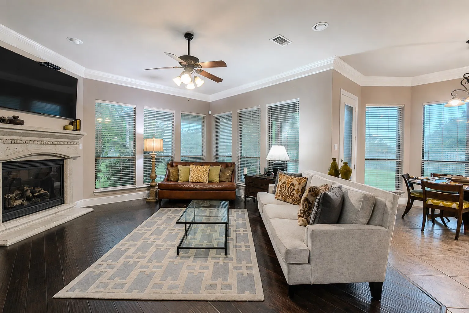 Gorgeous den with wood-burning fireplace, wood flooring and natural light.