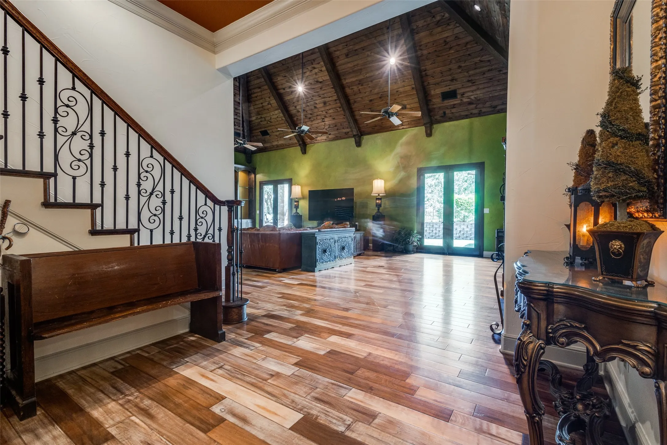 Living room with high vaulted ceiling, light wood-style flooring, plenty of natural light, stairs, and ceiling fan