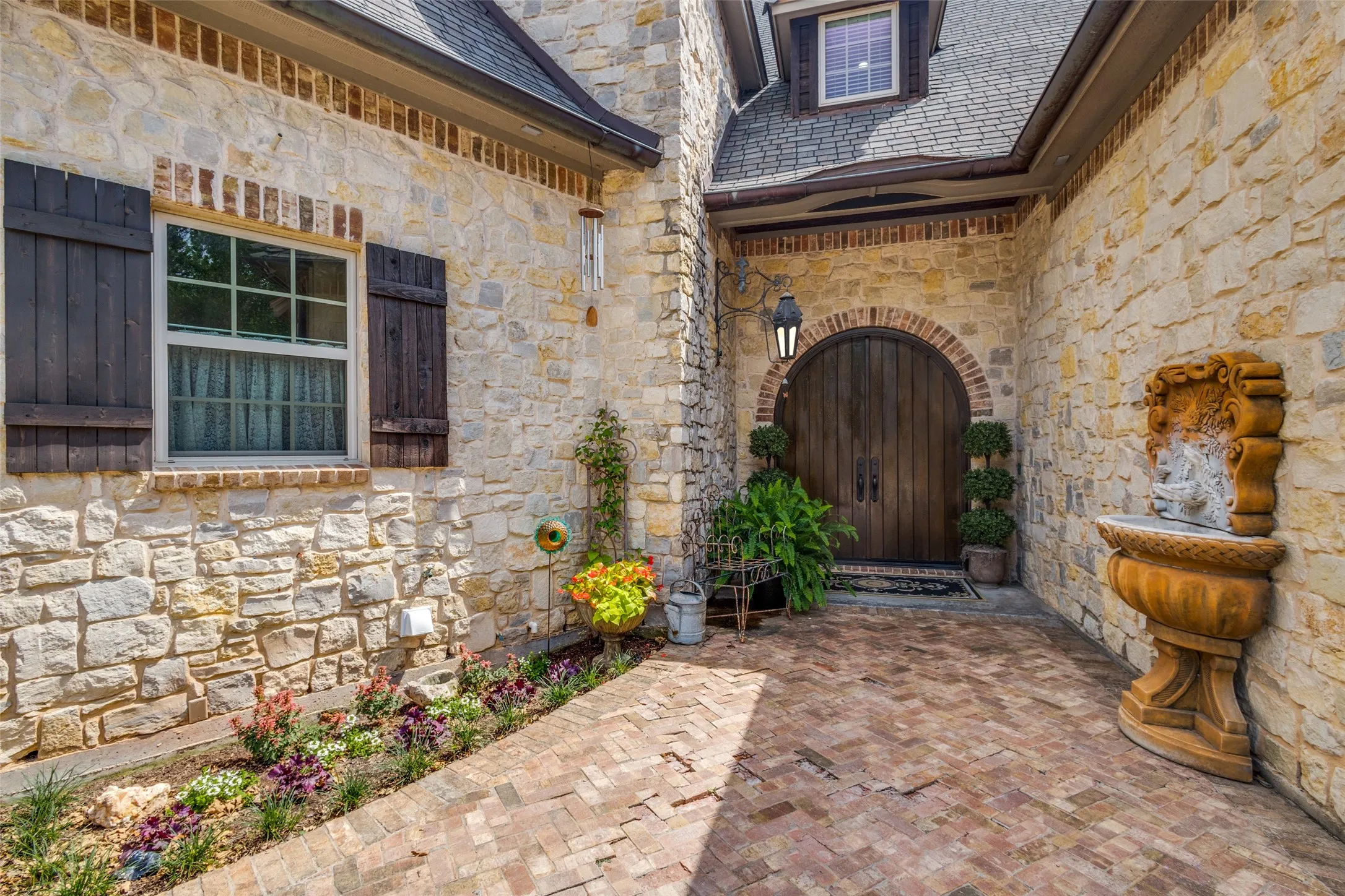 Entrance to property with stone siding and a high end roof