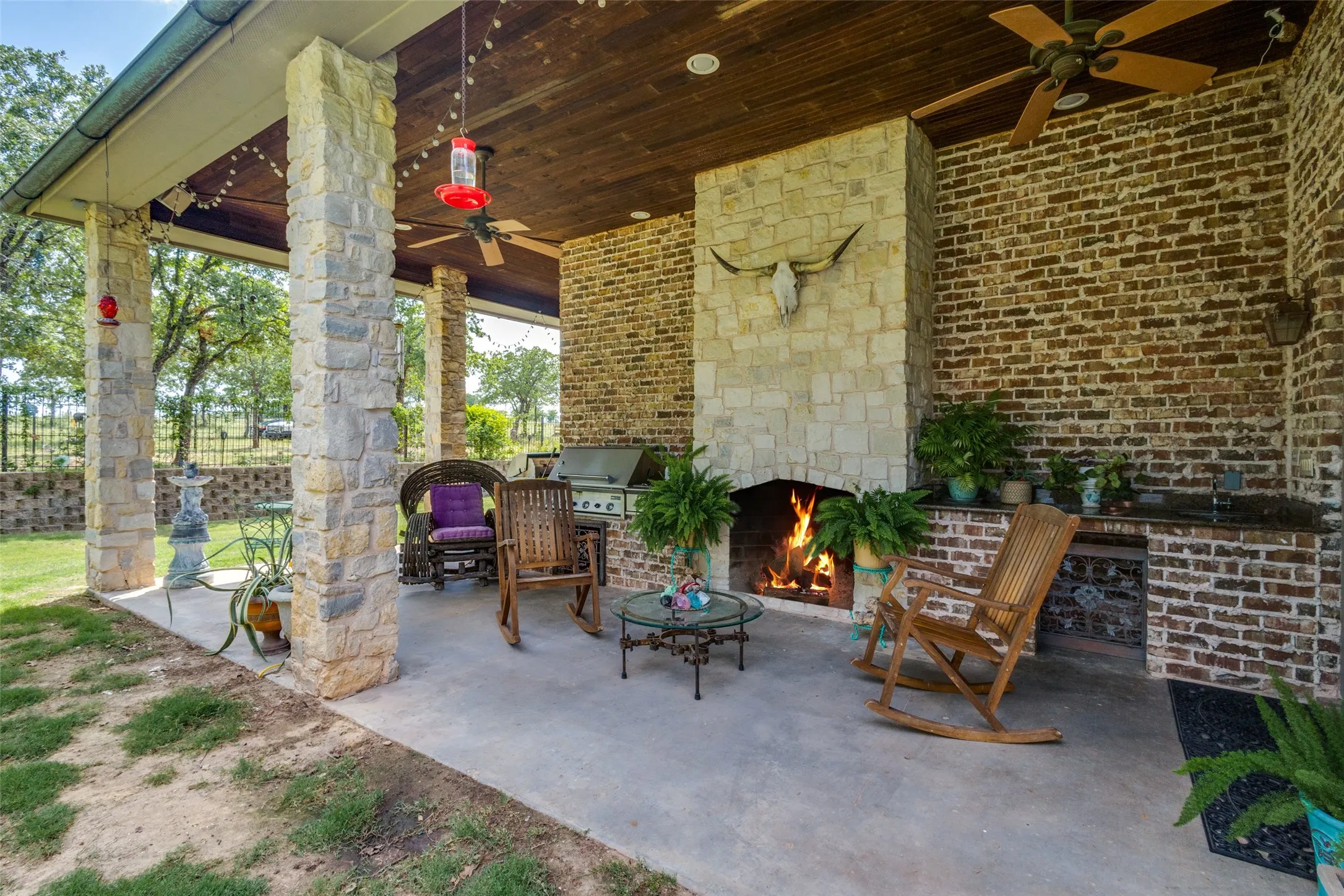 View of patio / terrace featuring ceiling fan, an outdoor stone fireplace, and area for grilling