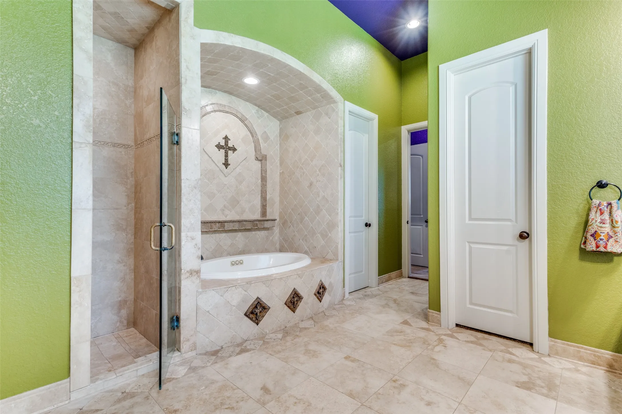 Bathroom featuring a textured wall, a shower stall, and a garden tub
