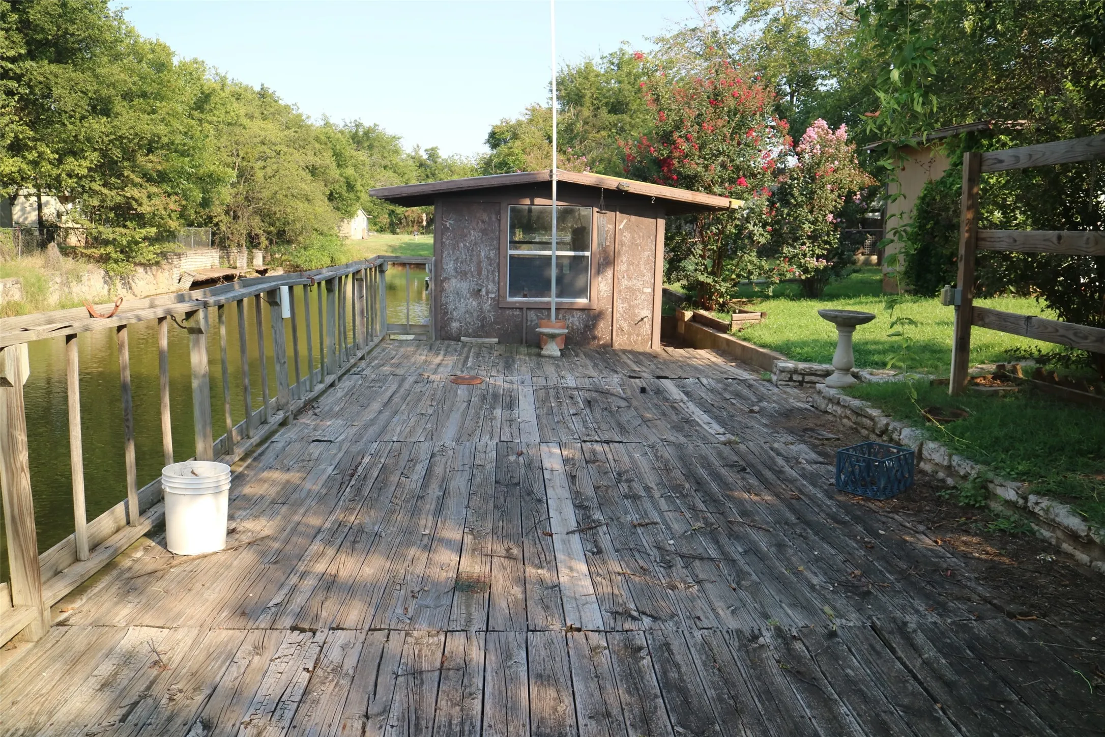Wooden deck with a water view and a yard