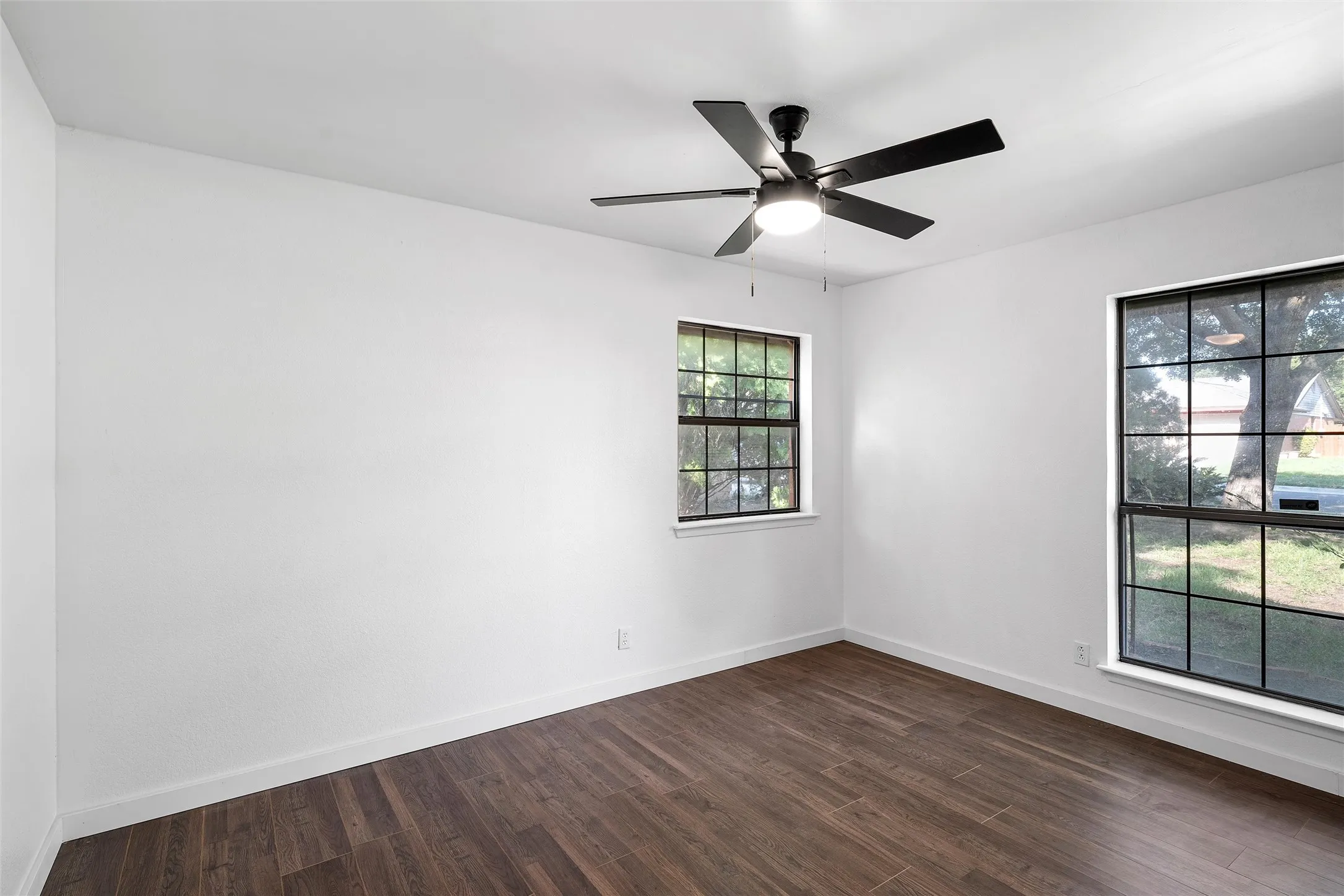 Spare room featuring dark wood-style floors and a ceiling fan