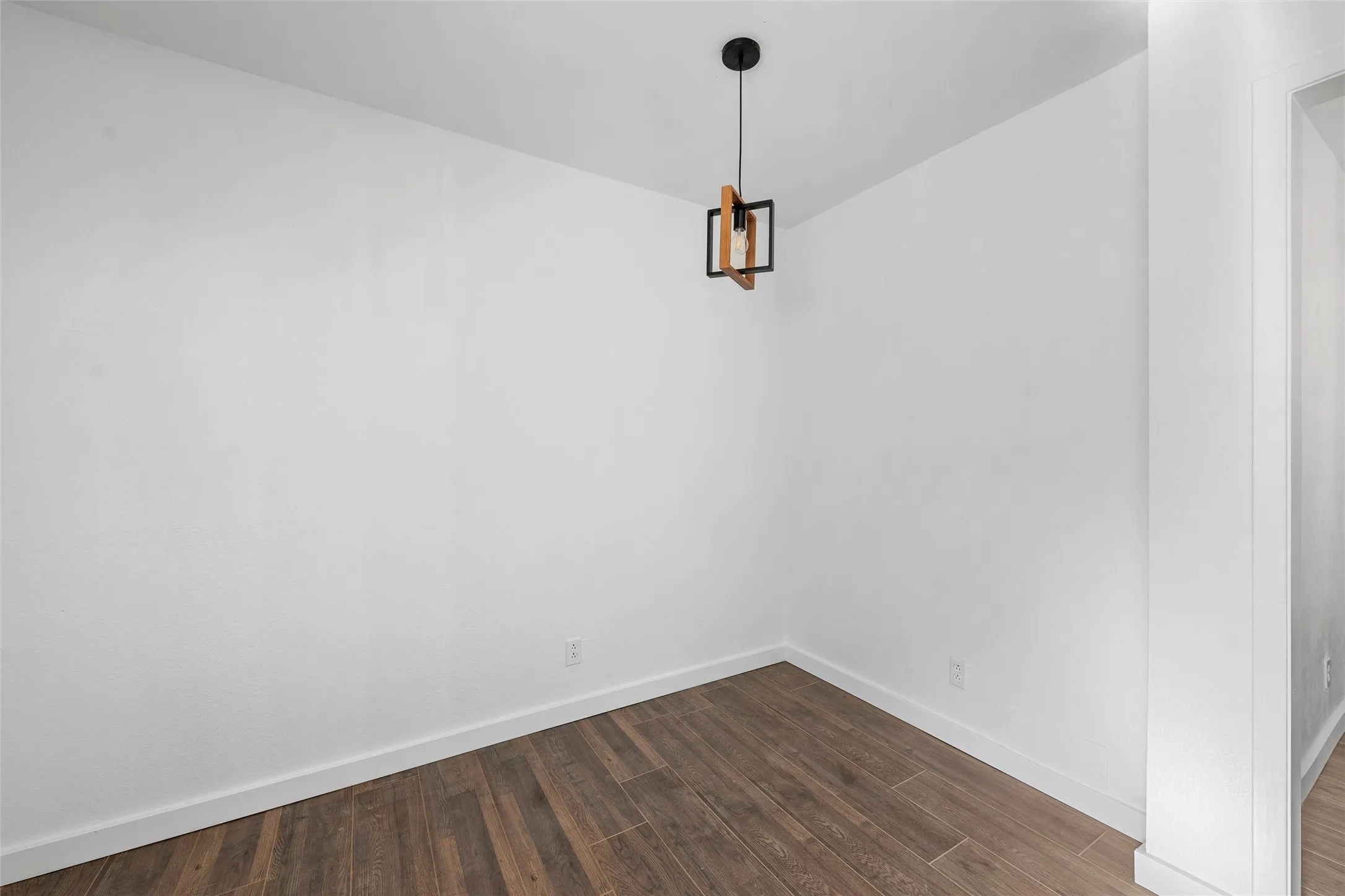 Unfurnished room featuring dark wood finished floors and baseboards
