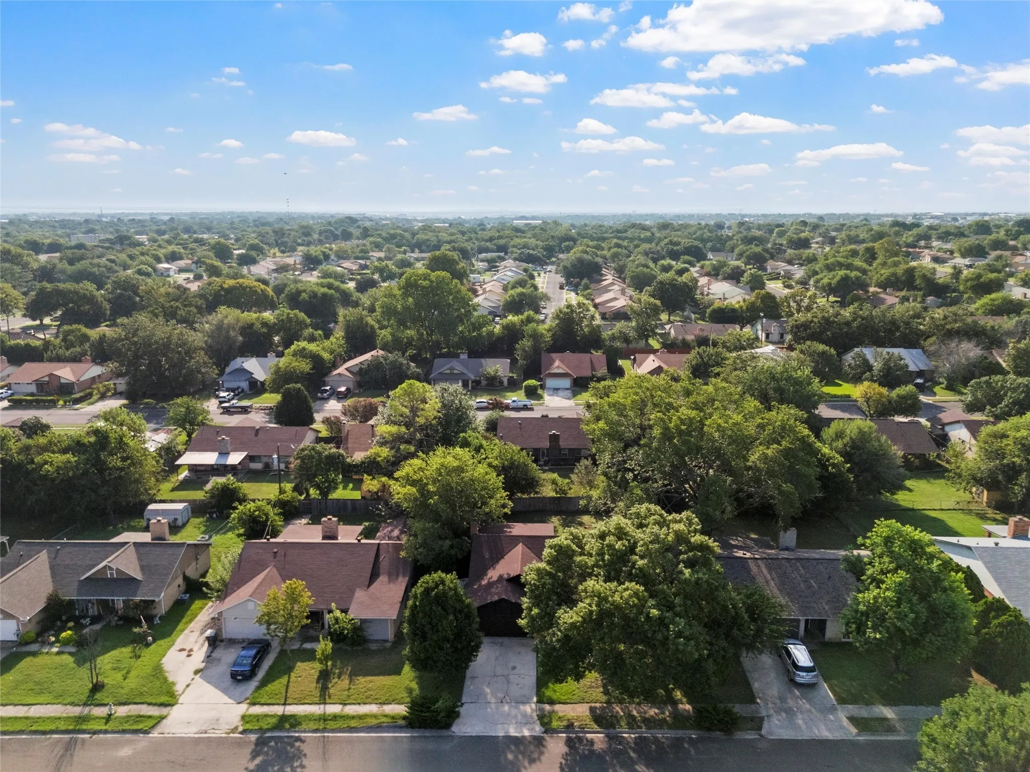 Aerial view of residential area featuring a tree filled landscape