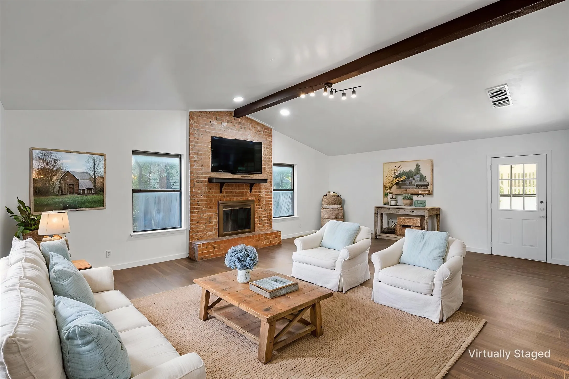 Living room with wood finished floors and a brick fireplace