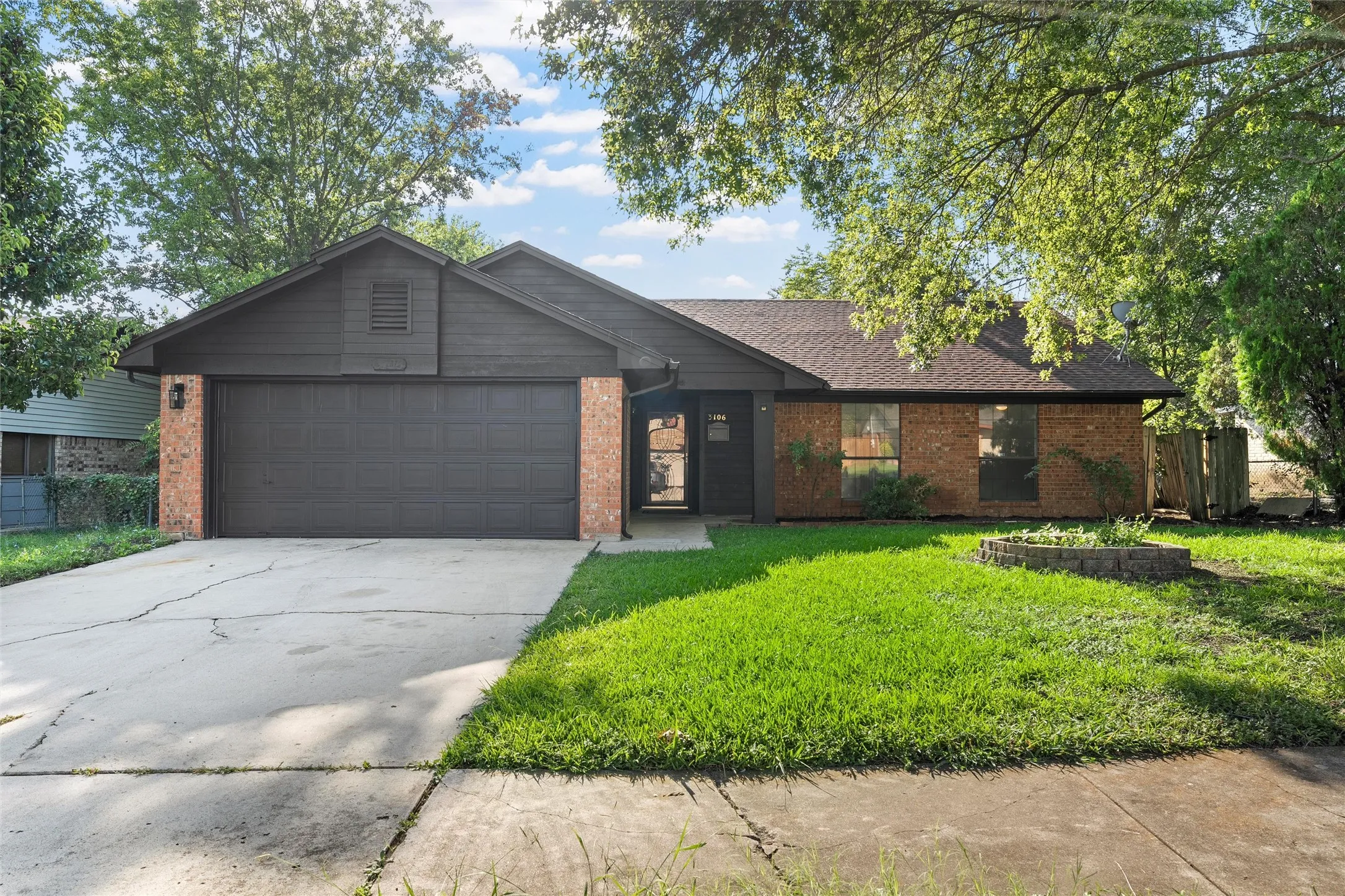 Ranch-style home featuring brick siding, an attached garage, and concrete driveway