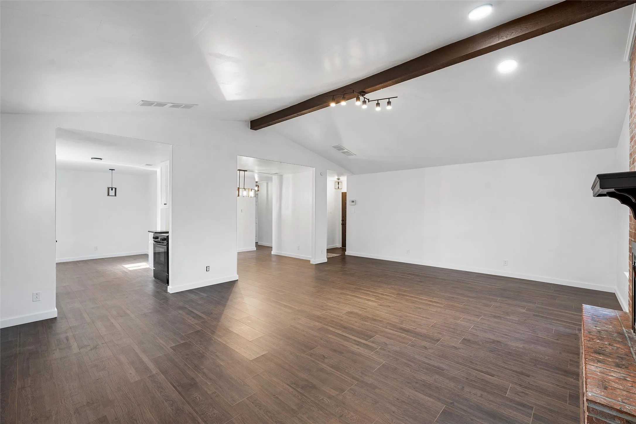 Unfurnished living room with dark wood-type flooring and a wood stove