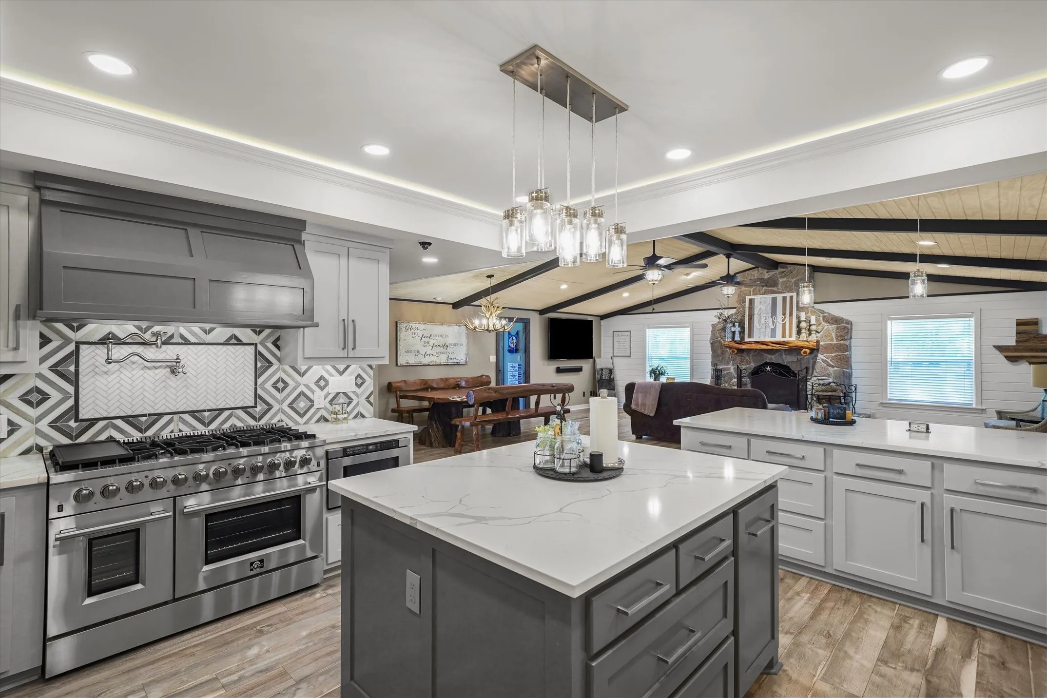 Kitchen with stainless steel appliances, hanging light fixtures, gray cabinets, and recessed lighting