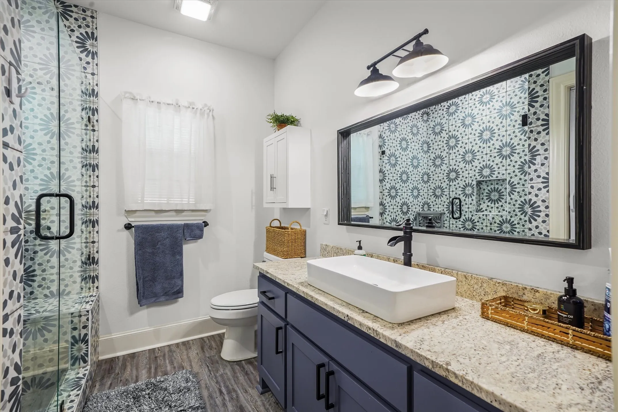 Full bathroom with vanity, dark wood-style flooring, and a shower stall