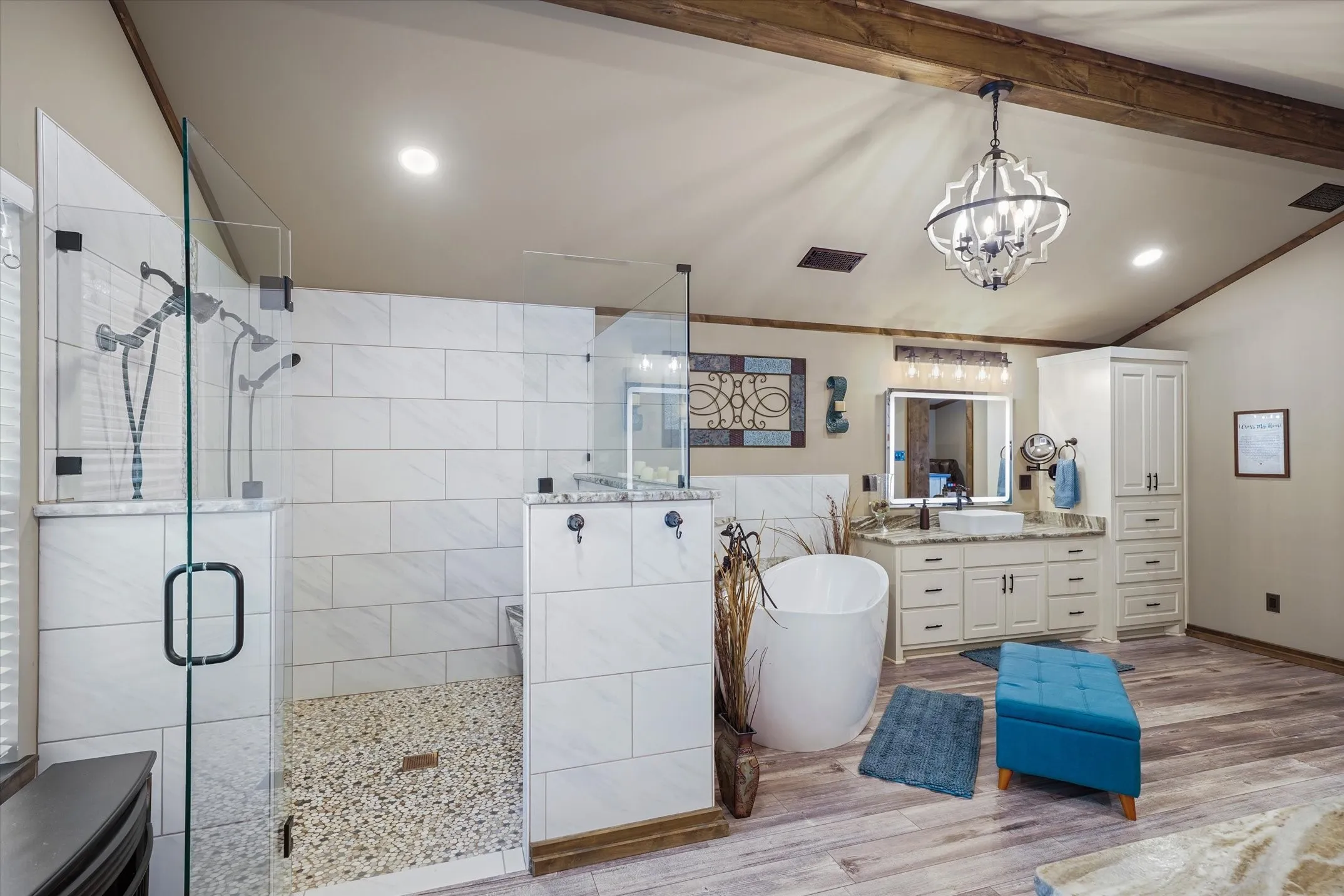 Bathroom featuring vaulted ceiling, a shower stall, a soaking tub, vanity, and light wood-type flooring