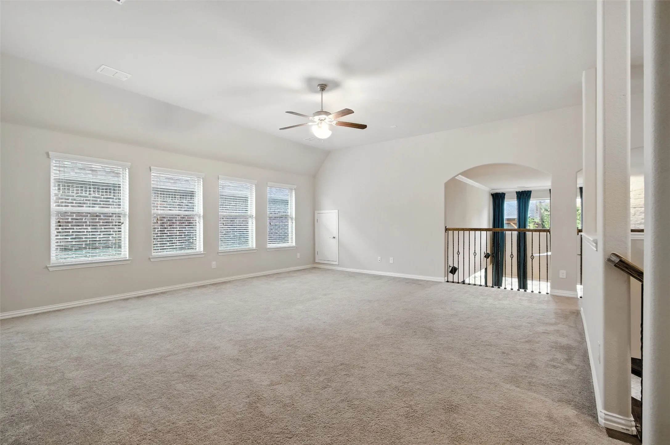 Spare room with carpet flooring, vaulted ceiling, and a ceiling fan