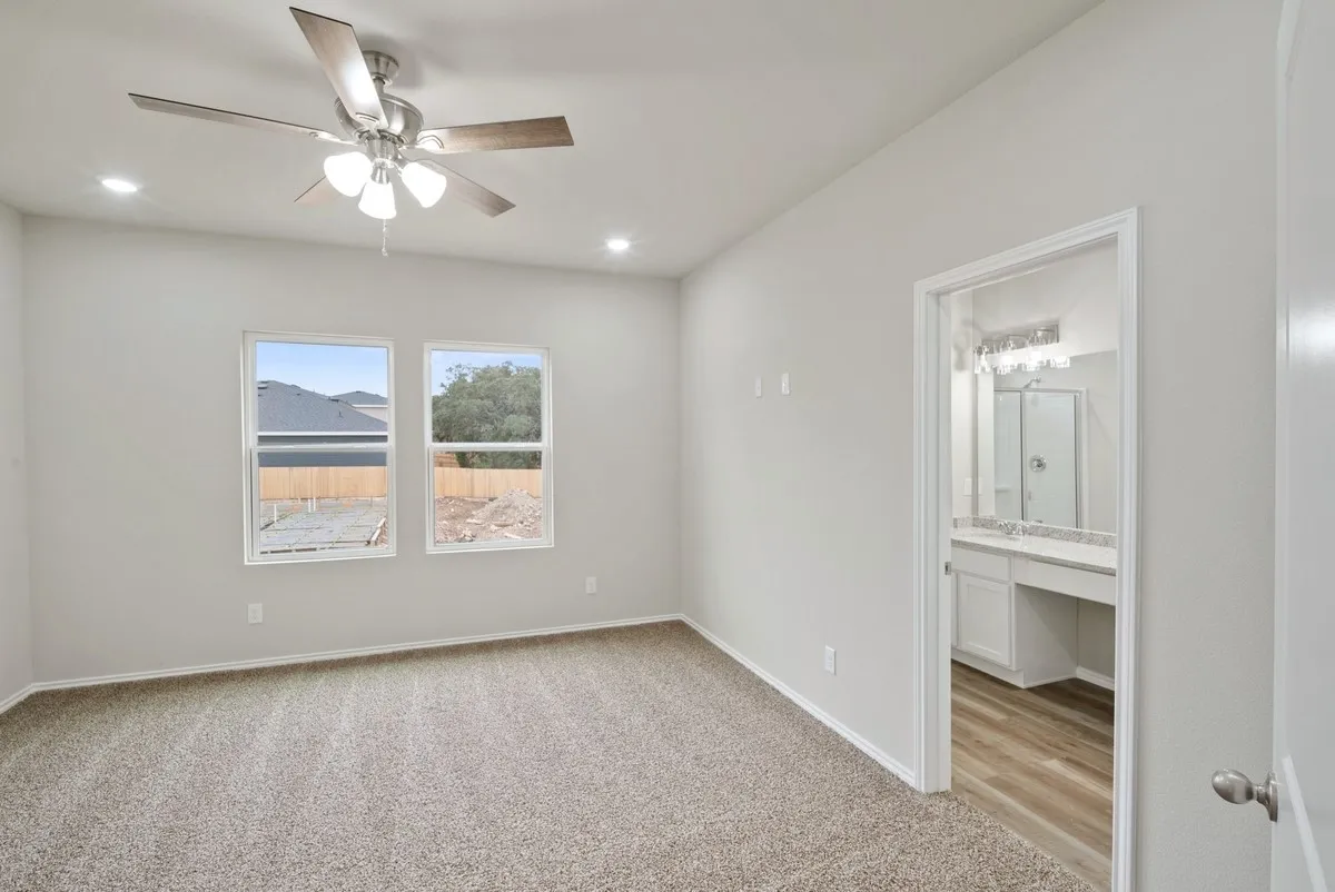 Unfurnished bedroom featuring light carpet, a ceiling fan, recessed lighting, and ensuite bathroom