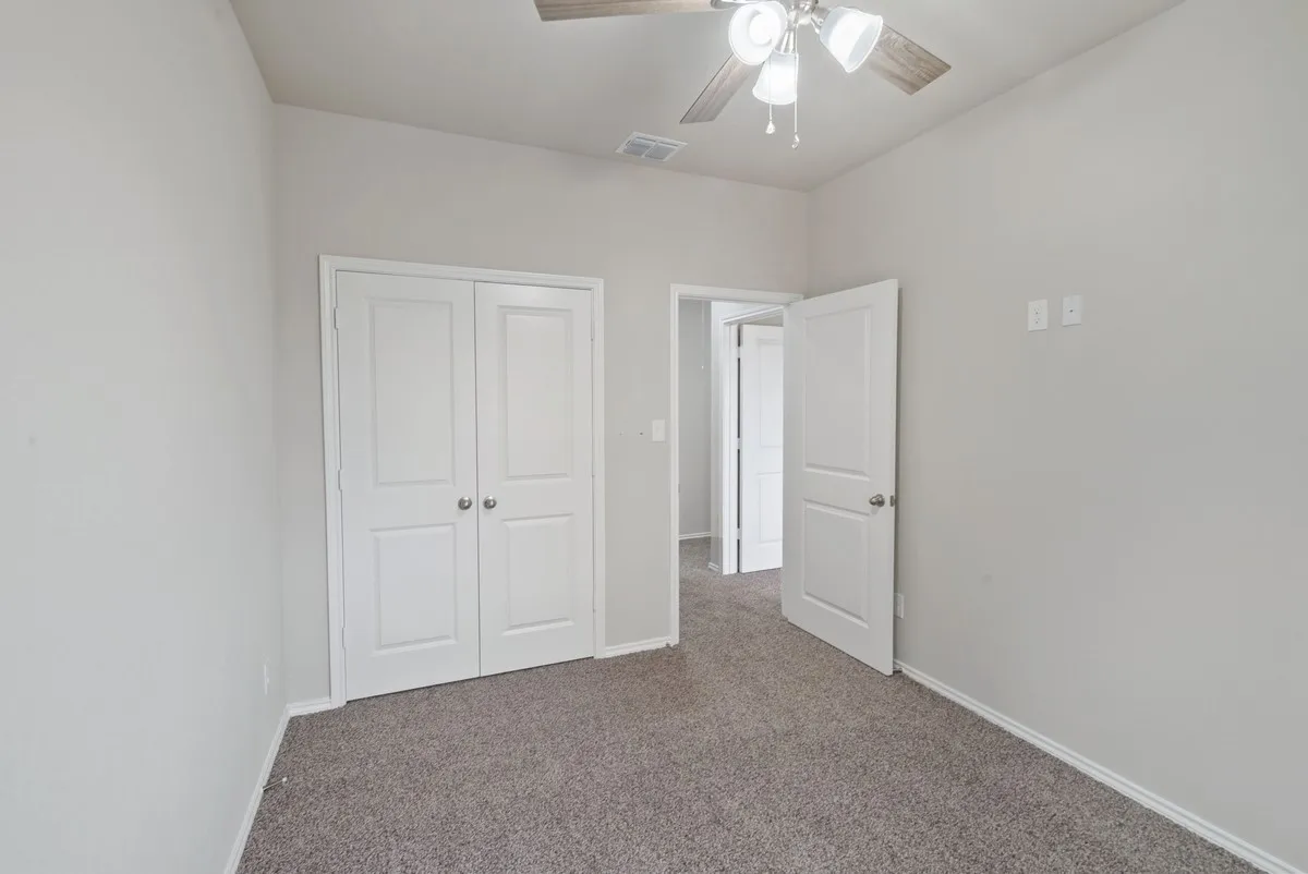 Unfurnished bedroom featuring carpet, ceiling fan, and a closet
