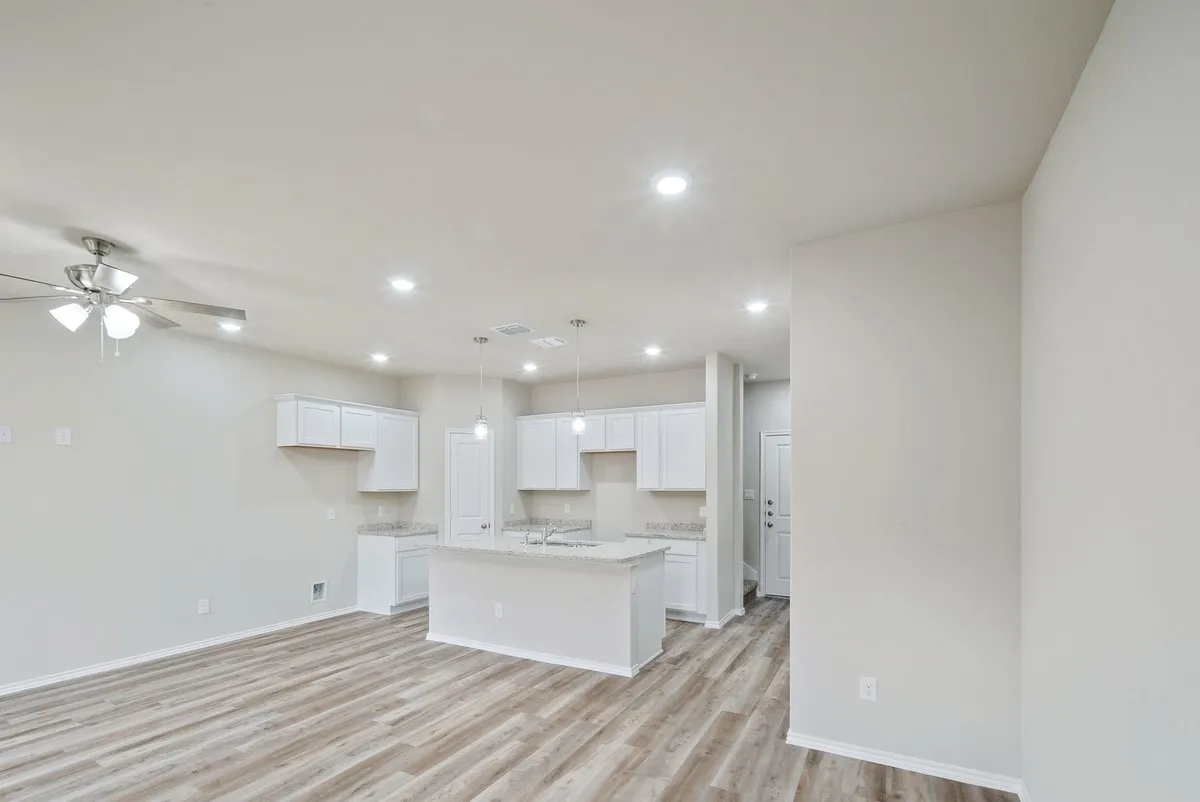 Kitchen featuring white cabinetry, a center island with sink, recessed lighting, light wood finished floors, and pendant lighting