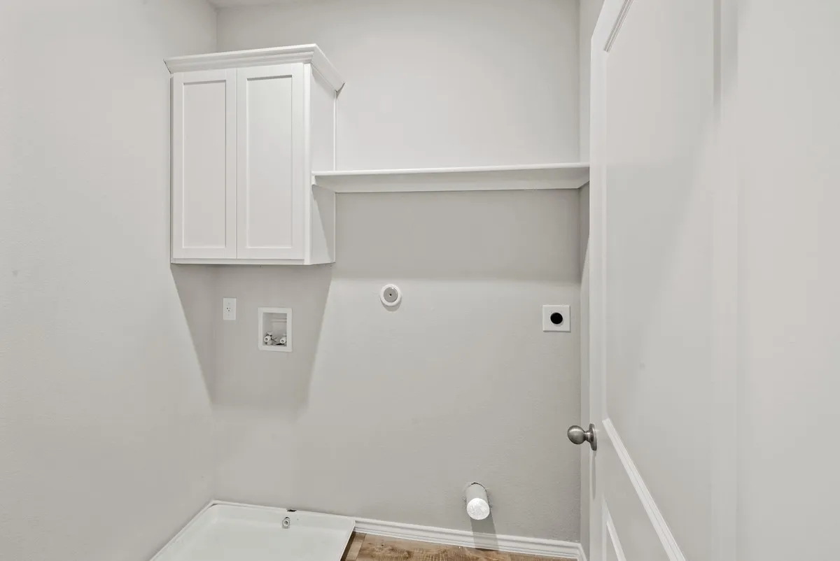Washroom with hookup for a gas dryer, hookup for a washing machine, hookup for an electric dryer, and cabinet space