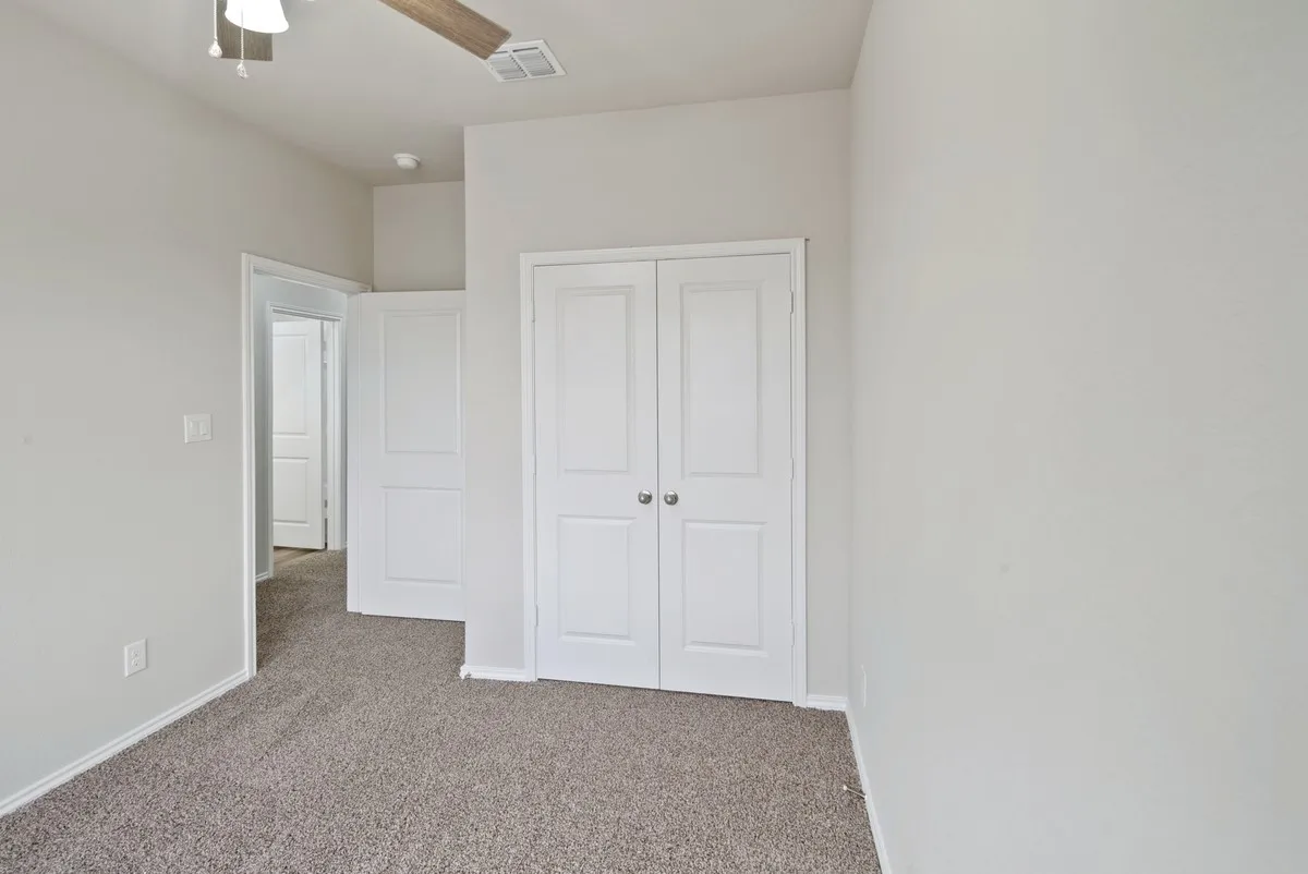 Unfurnished bedroom with carpet flooring, a ceiling fan, and a closet
