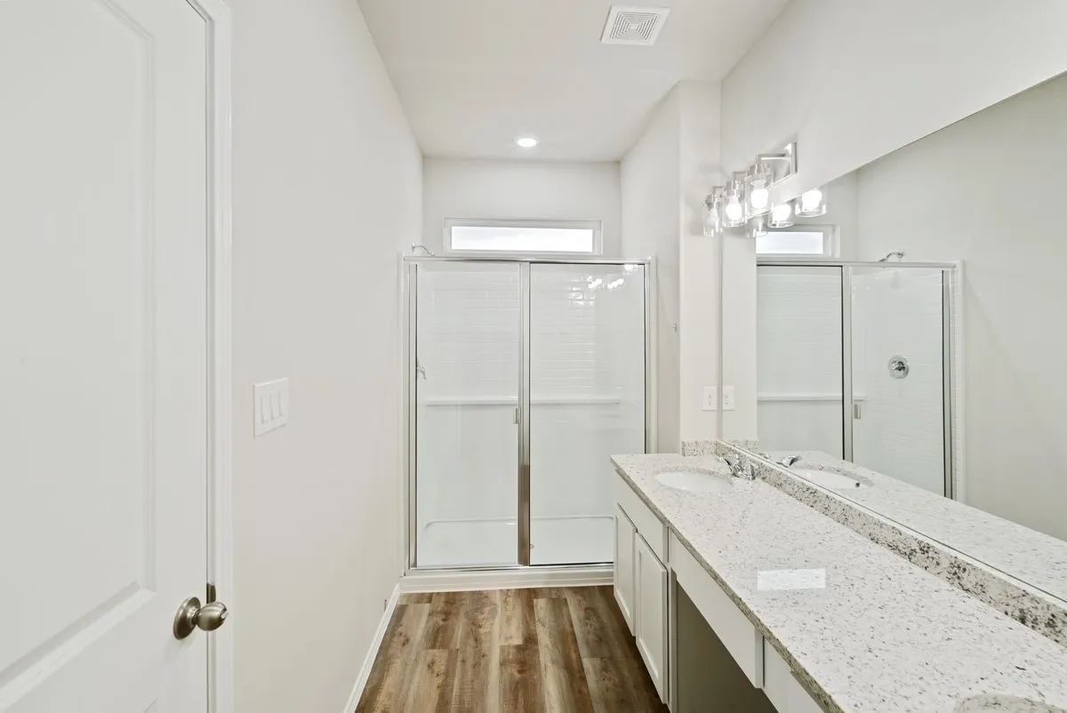 Full bathroom featuring a shower stall, vanity, and dark wood-style floors