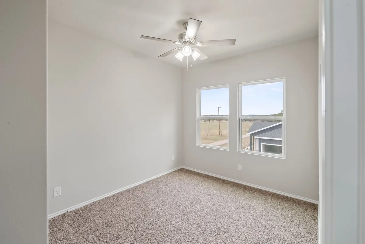 Unfurnished room featuring carpet and ceiling fan