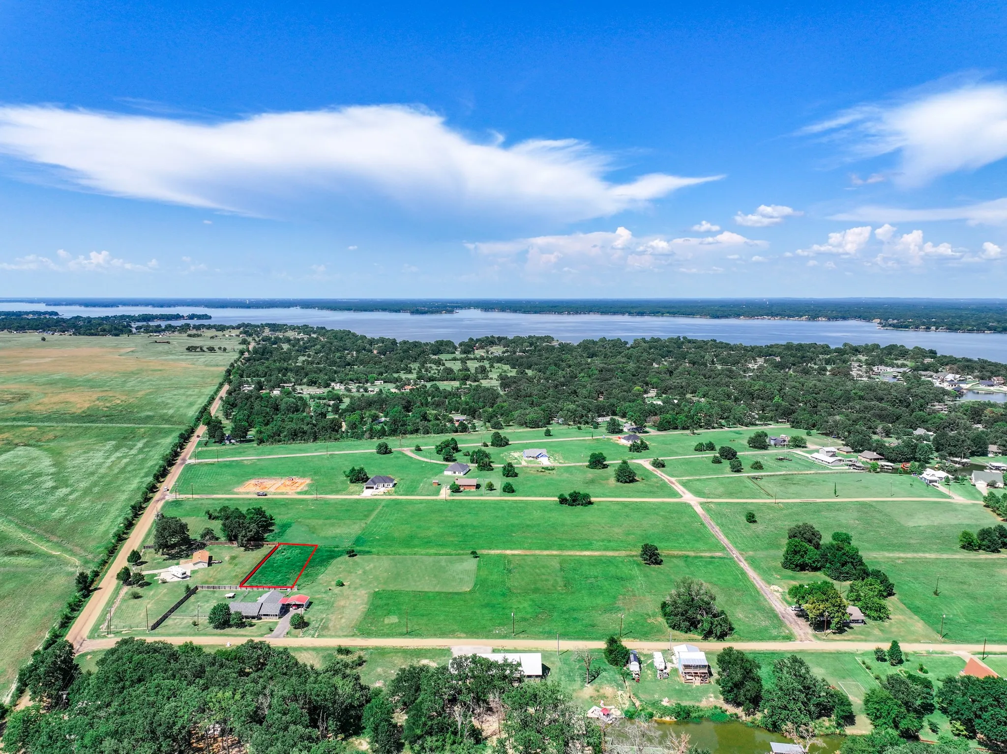 Overview of rural landscape with a nearby body of water and property boundaries highlighted