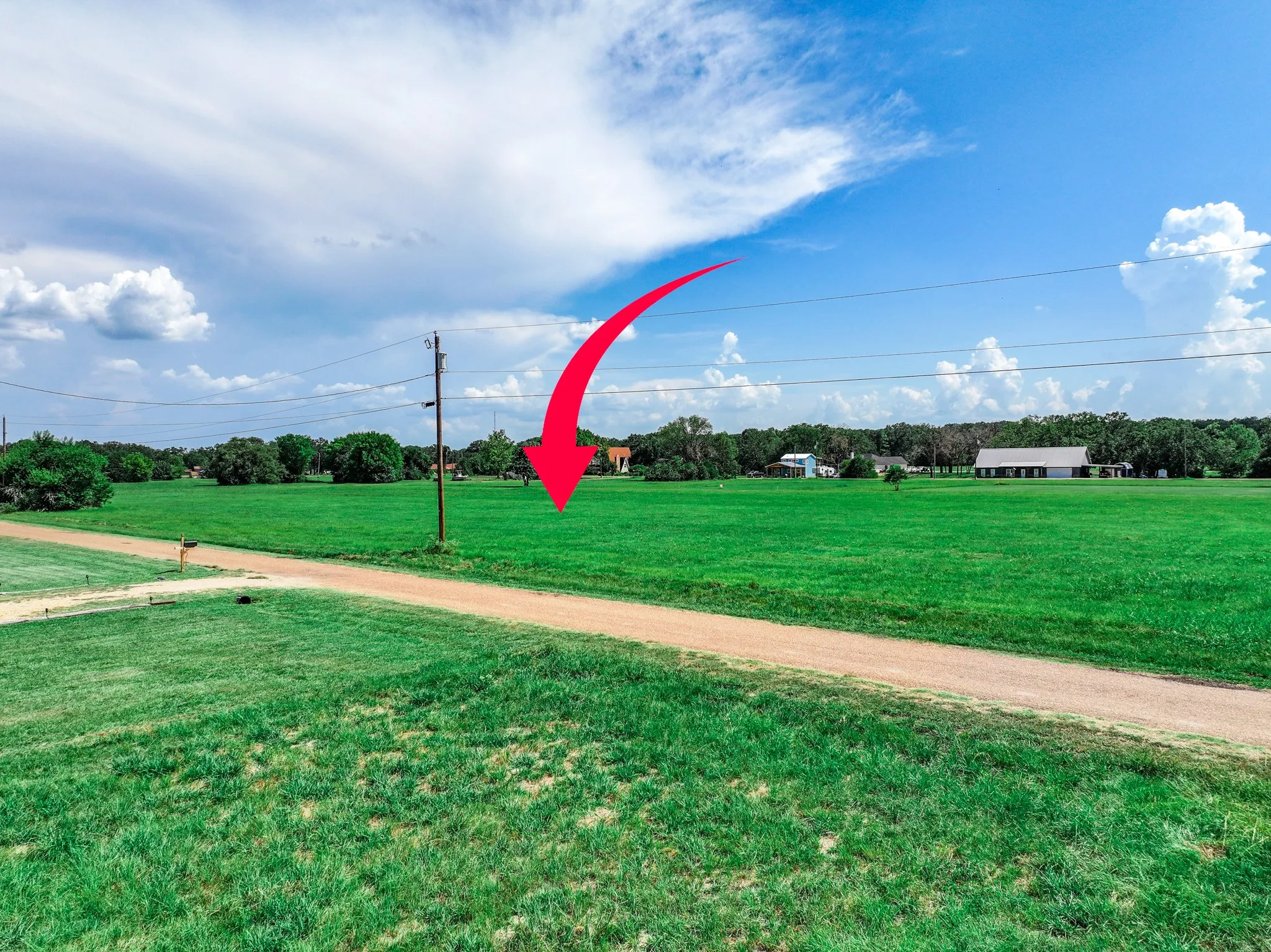 View of property's community featuring a lawn and view of wooded area