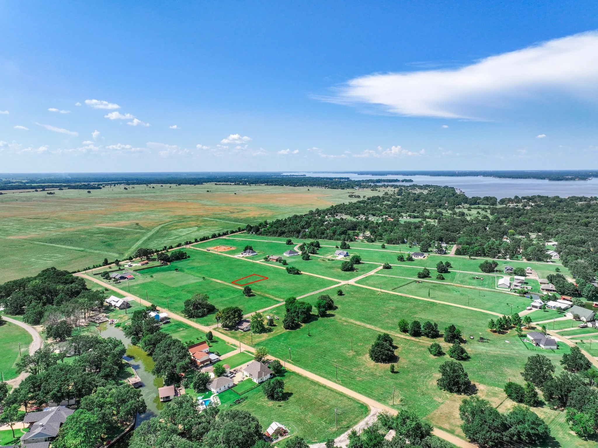 Aerial view of property and surrounding area with rural landscape and a nearby body of water