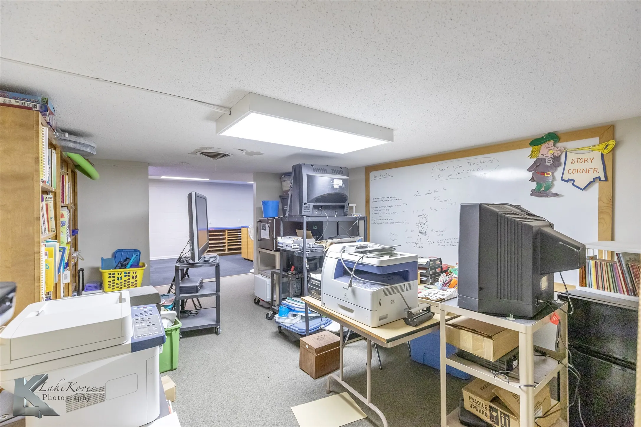 Office area featuring light carpet and a textured ceiling