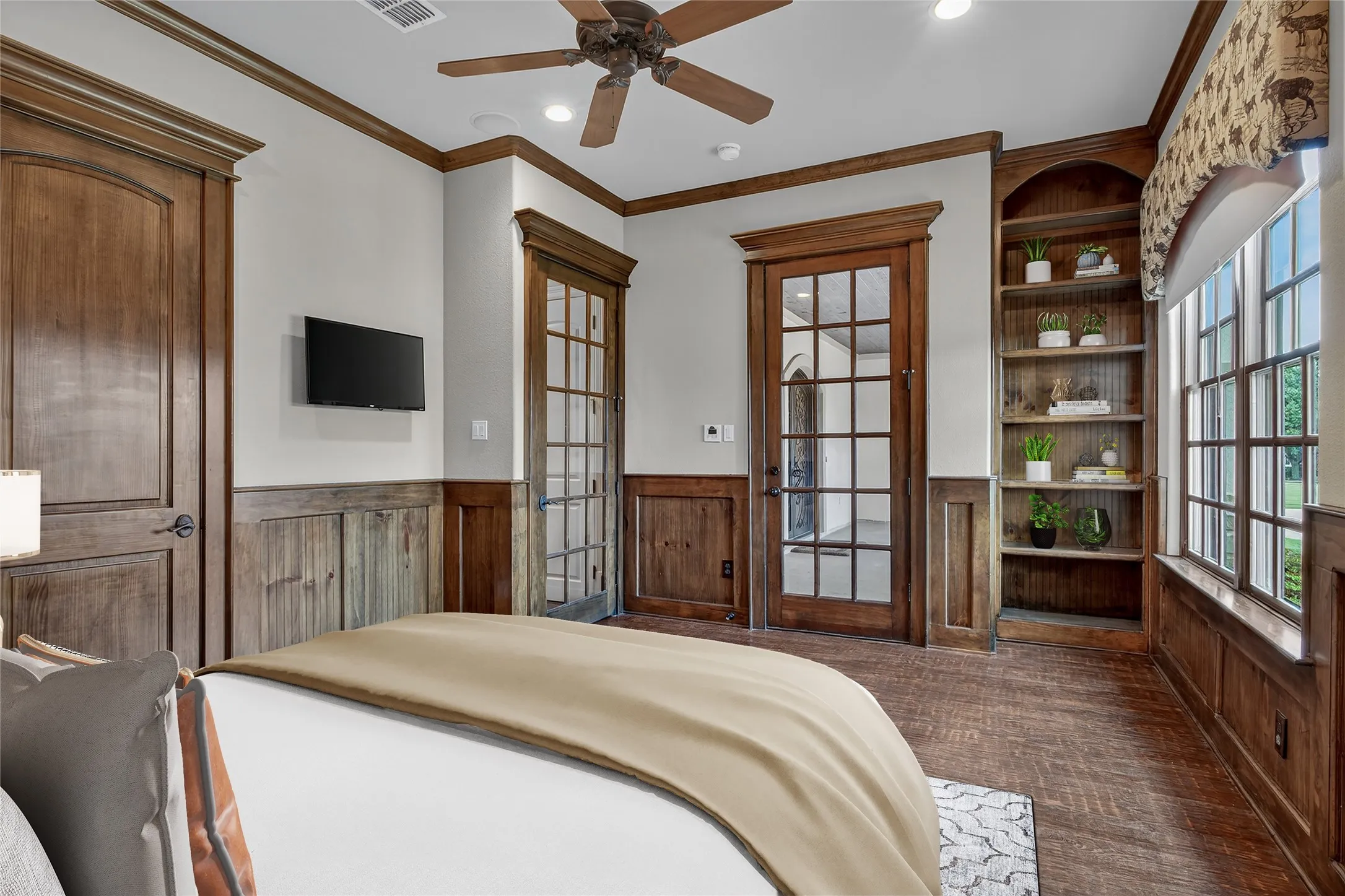 Tucked away at the front of this exquisite six-bedroom estate, this versatile bedroom offers both comfort and convenience. Featuring rich hand-scraped wood floors, a full en-suite bath, and a private exit to the front porch, this space is perfectly suited for use as an in-law suite, a renter’s retreat, an executive office, or even a serene home gym. With its thoughtful layout and elegant finishes, the possibilities are endless—flexible living at its finest. This photo has been virtually staged.