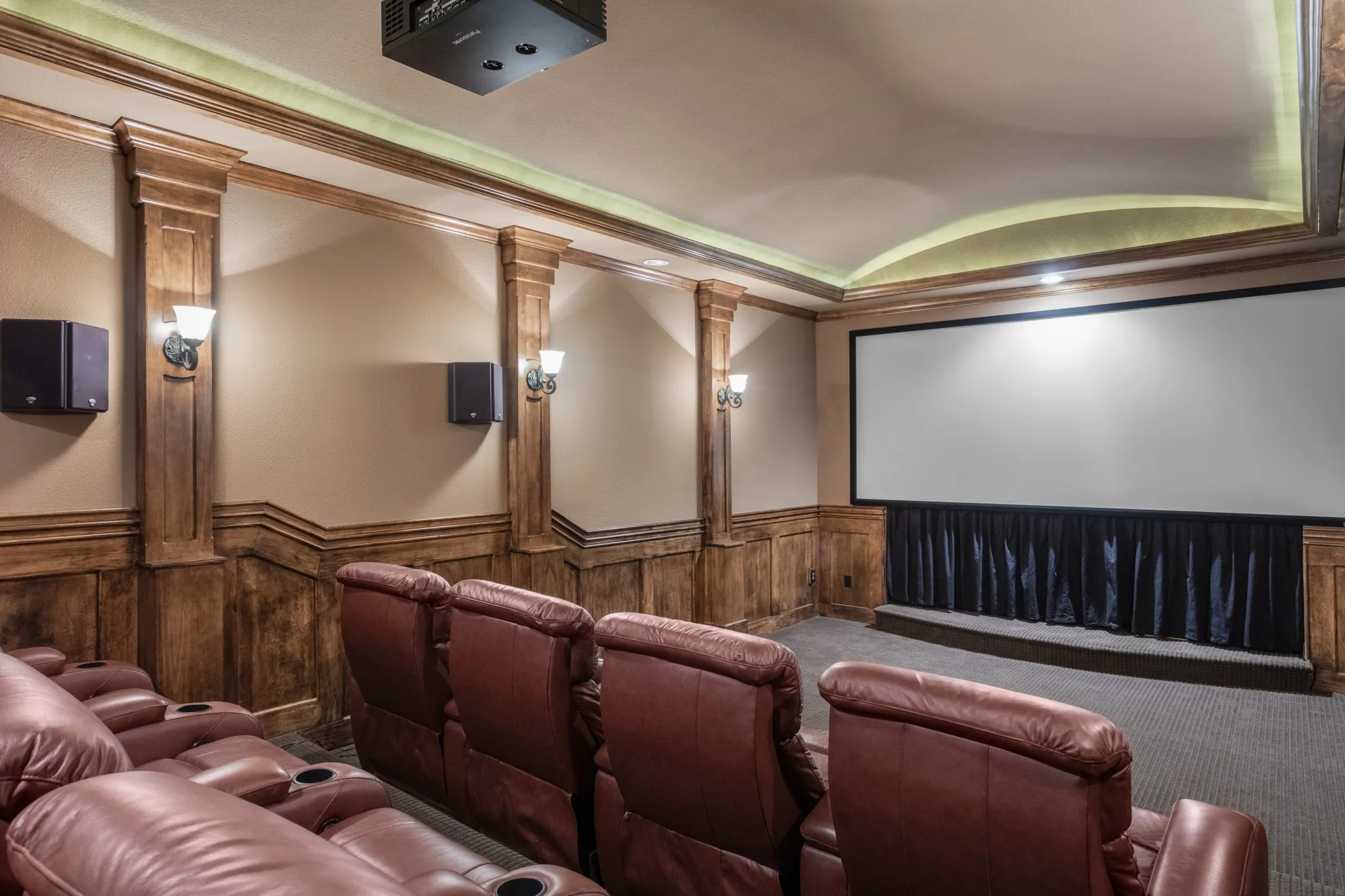 Indulge in cinematic splendor in this state-of-the-art private home theater, designed for the ultimate viewing experience. Featuring a massive 158-inch, 2.35:1 acoustically transparent screen, every frame is brought to life with stunning clarity while delivering unmatched sound immersion through premium Klipsch surround speakers. Two-tiered leather recliner seating ensures every guest has the best seat in the house, while rich wood-paneled walls and ambient lighting elevate the ambiance. Whether you're screening the latest blockbuster or hosting movie night, this luxurious theater promises unforgettable entertainment.