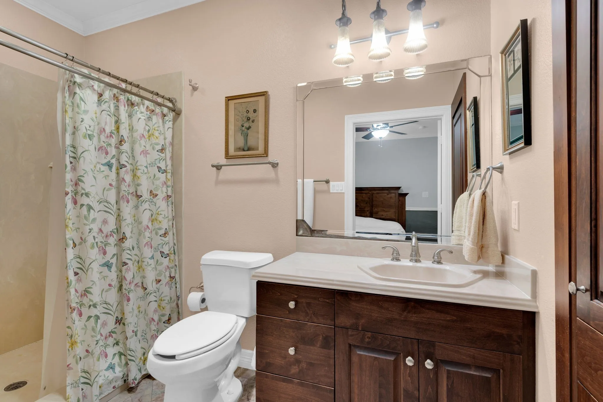 Bathroom with vanity, a shower stall, connected bathroom, crown molding, and a ceiling fan