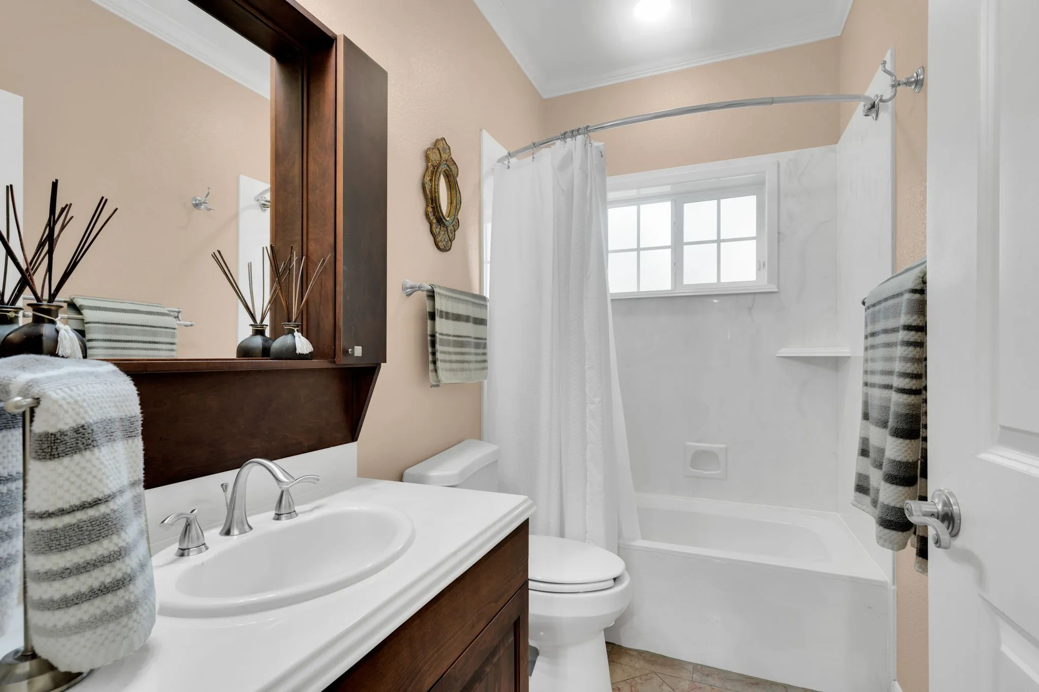 Bathroom with shower / tub combo, ornamental molding, vanity, and light tile patterned floors