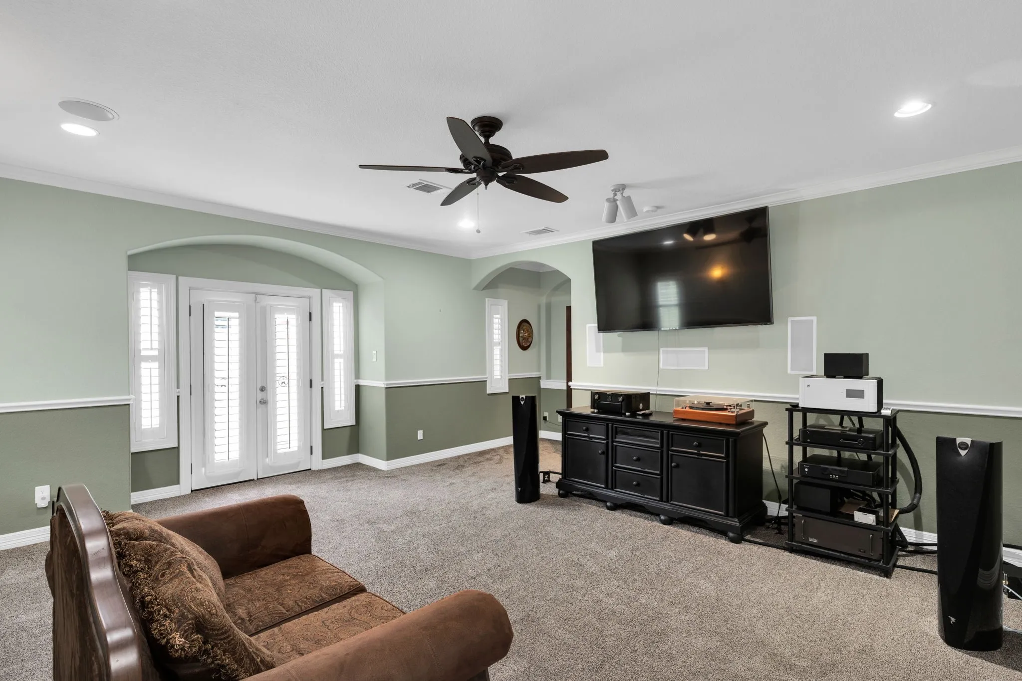 Living room featuring crown molding, carpet flooring, arched walkways, french doors, and recessed lighting