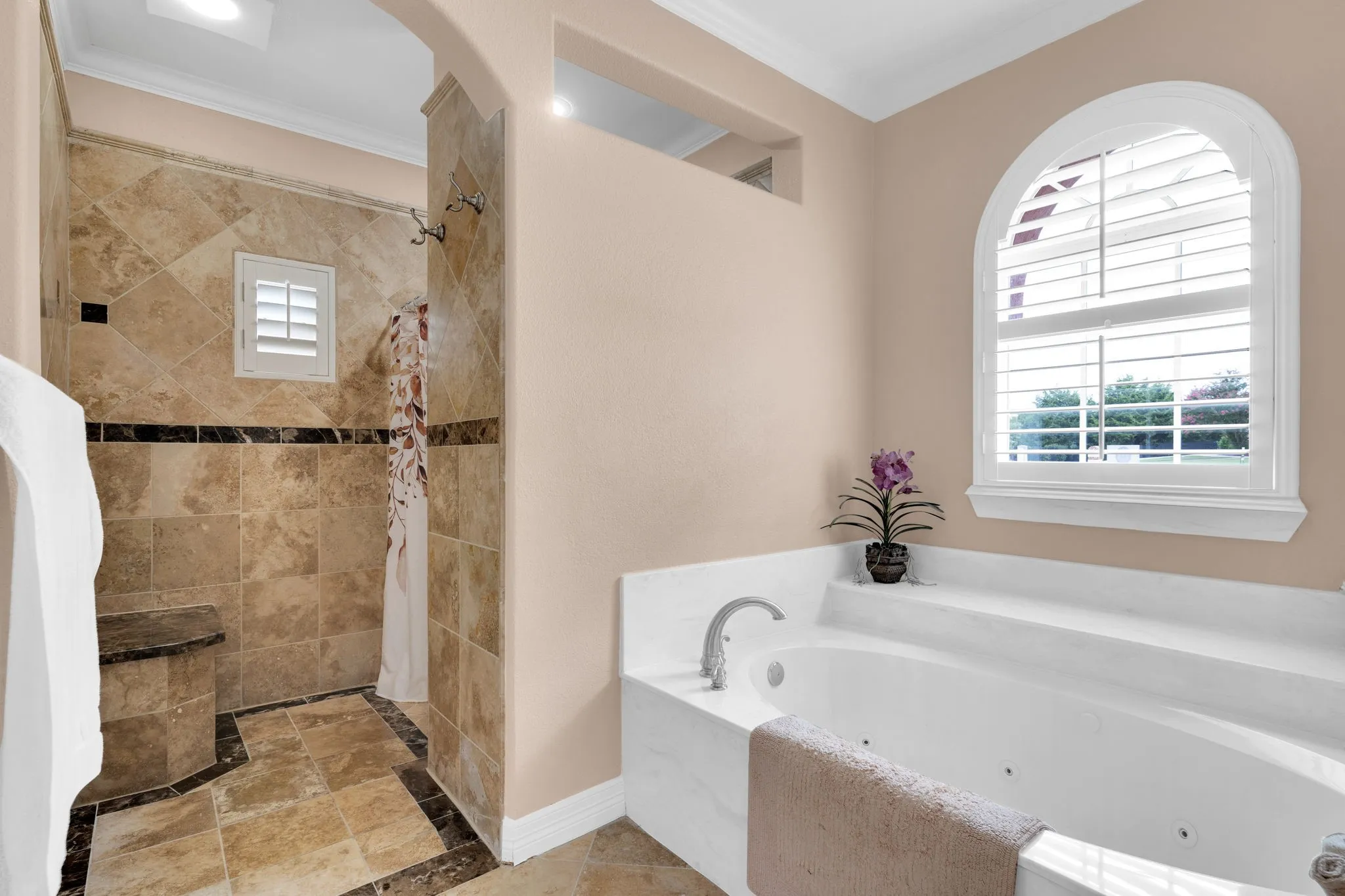 Full bath featuring a stall shower, a jetted tub, and crown molding