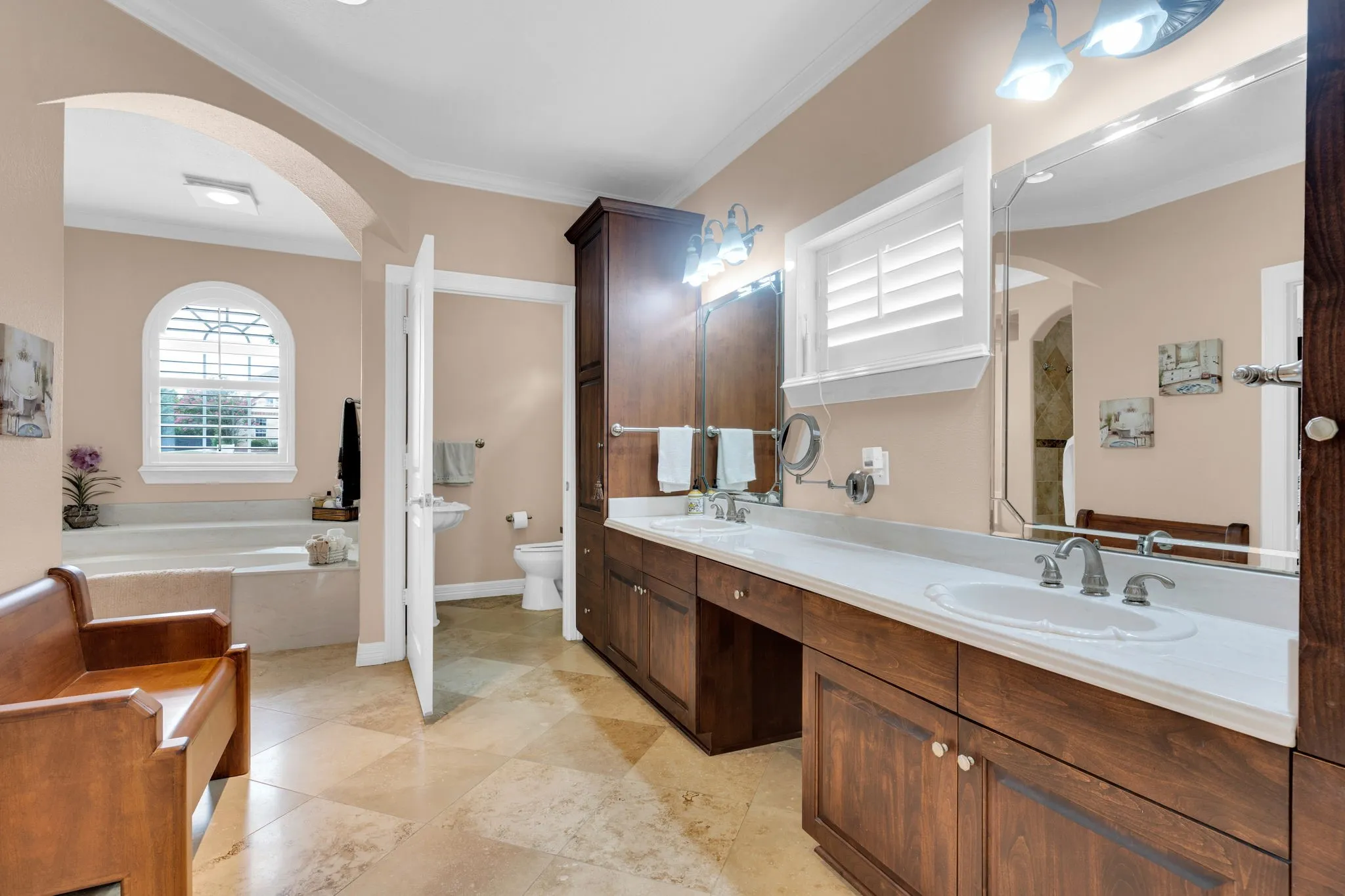 Bathroom featuring double vanity, ornamental molding, and a bath