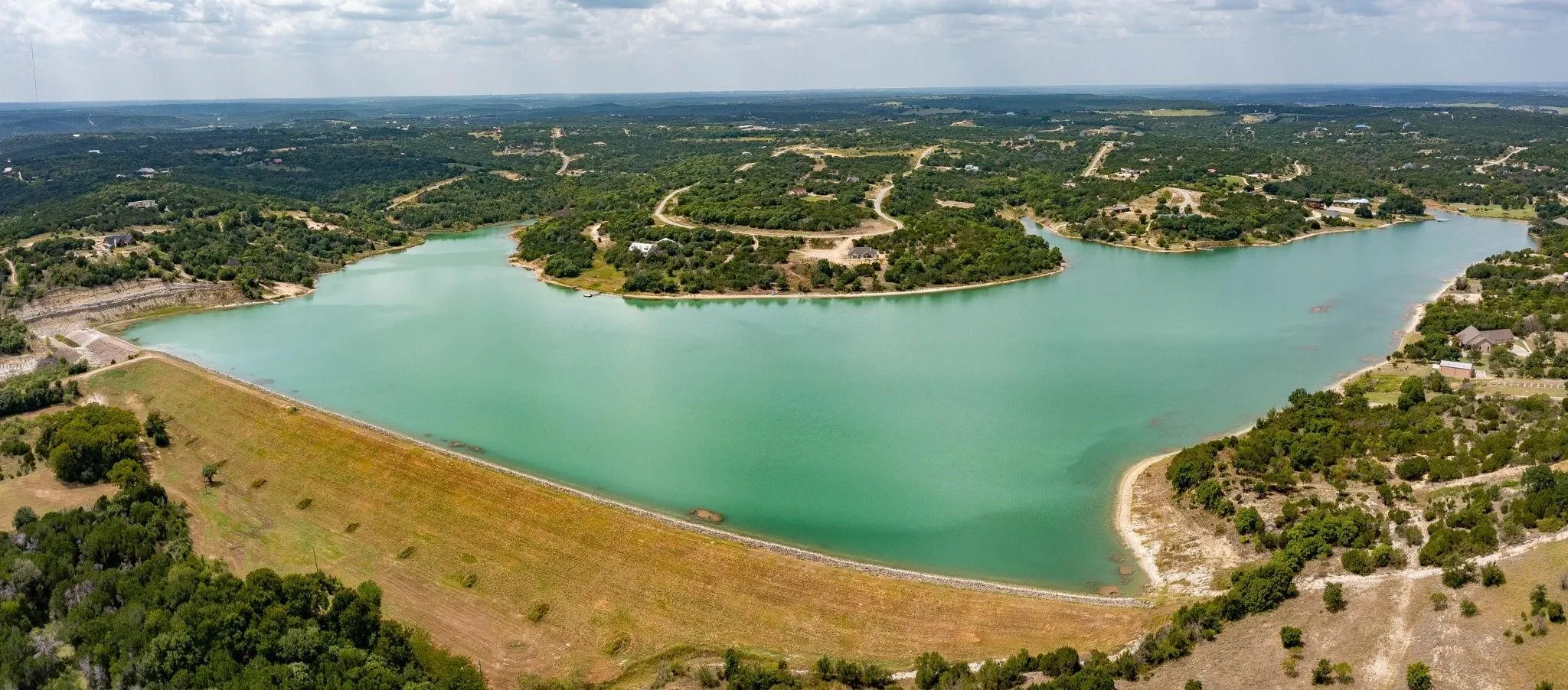 Aerial view of property's location with a large body of water and a heavily wooded area