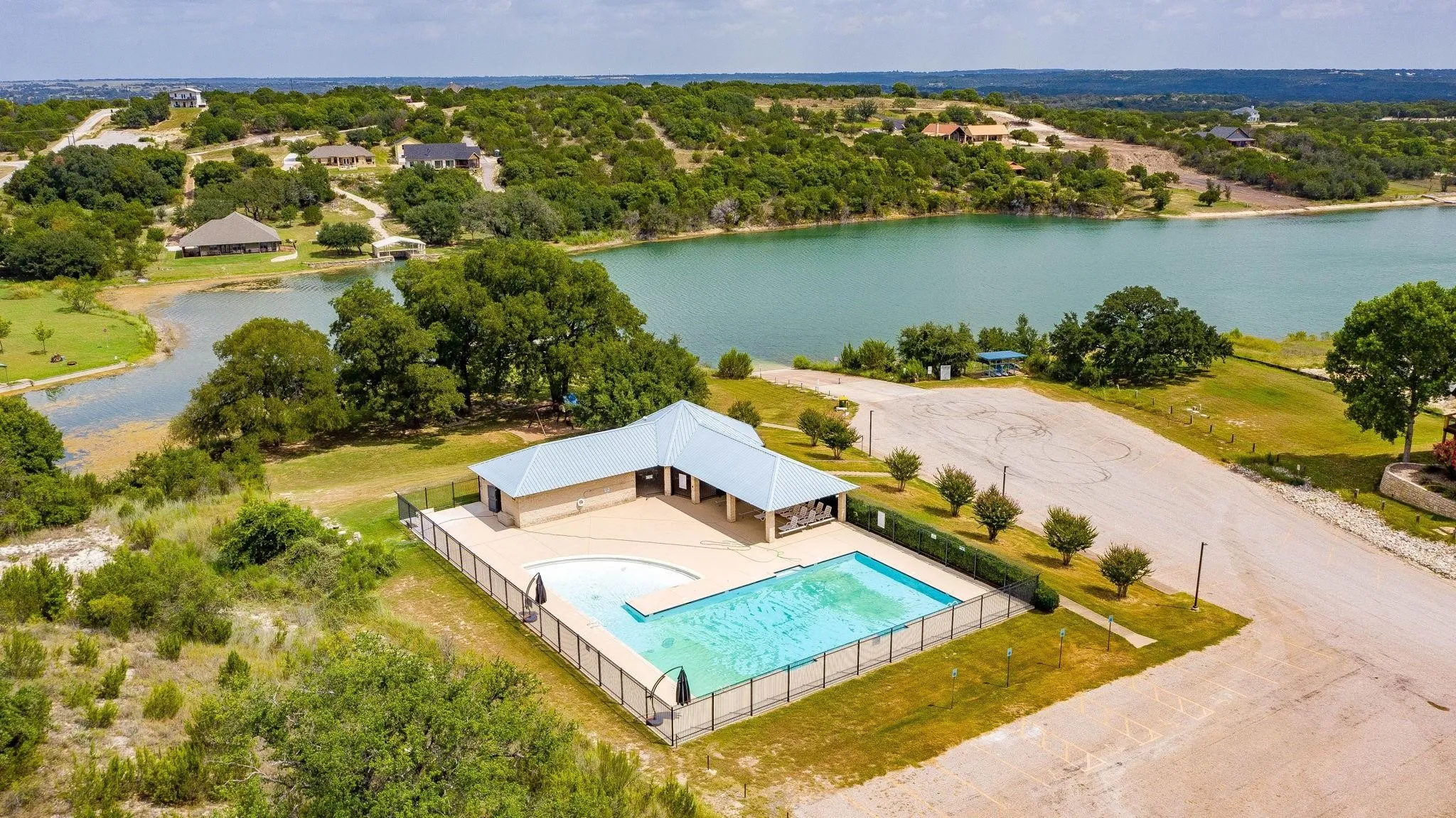 Aerial view of a pool area and a nearby body of water