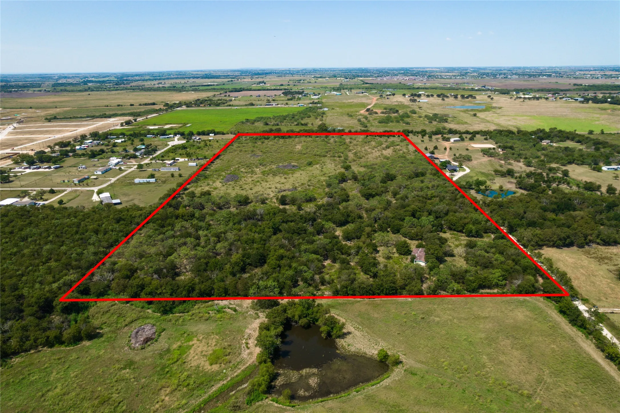 Aerial view of sparsely populated area featuring property parcel outlined