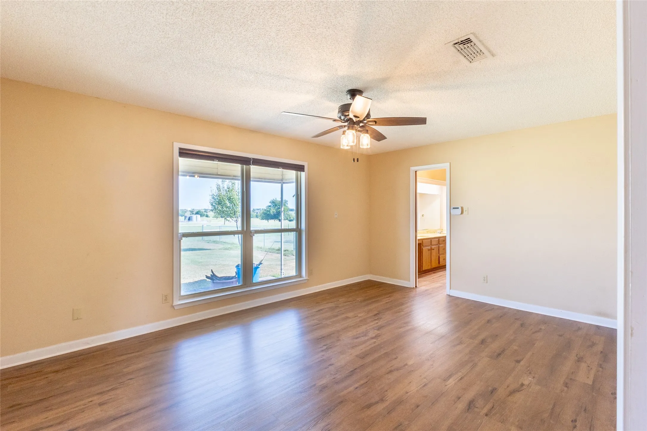 Unfurnished room with wood finished floors, a textured ceiling, and ceiling fan
