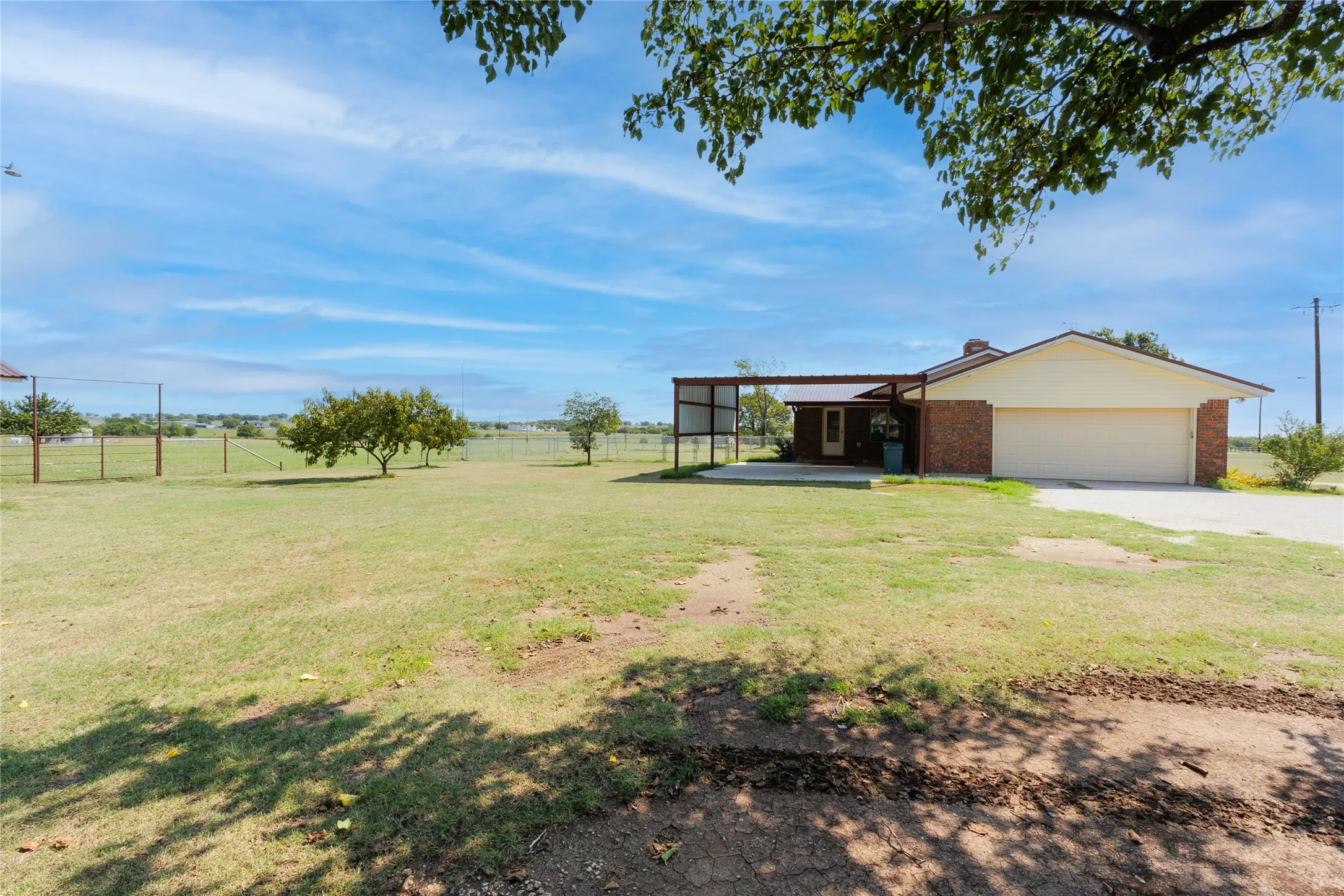 View of yard with driveway, a garage, and a patio