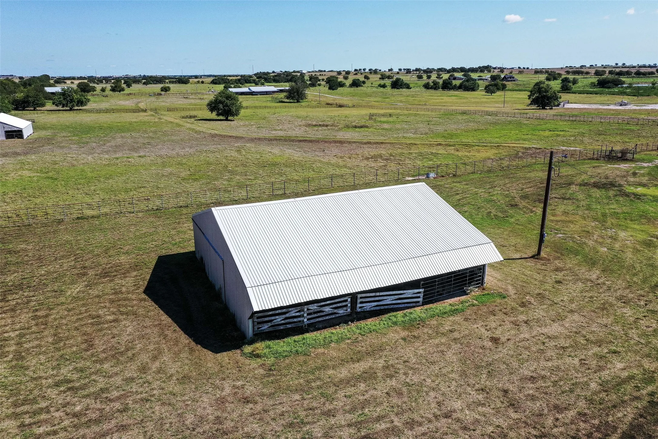 View of storm shelter with a rural view, an outdoor structure, an outbuilding, and a lawn