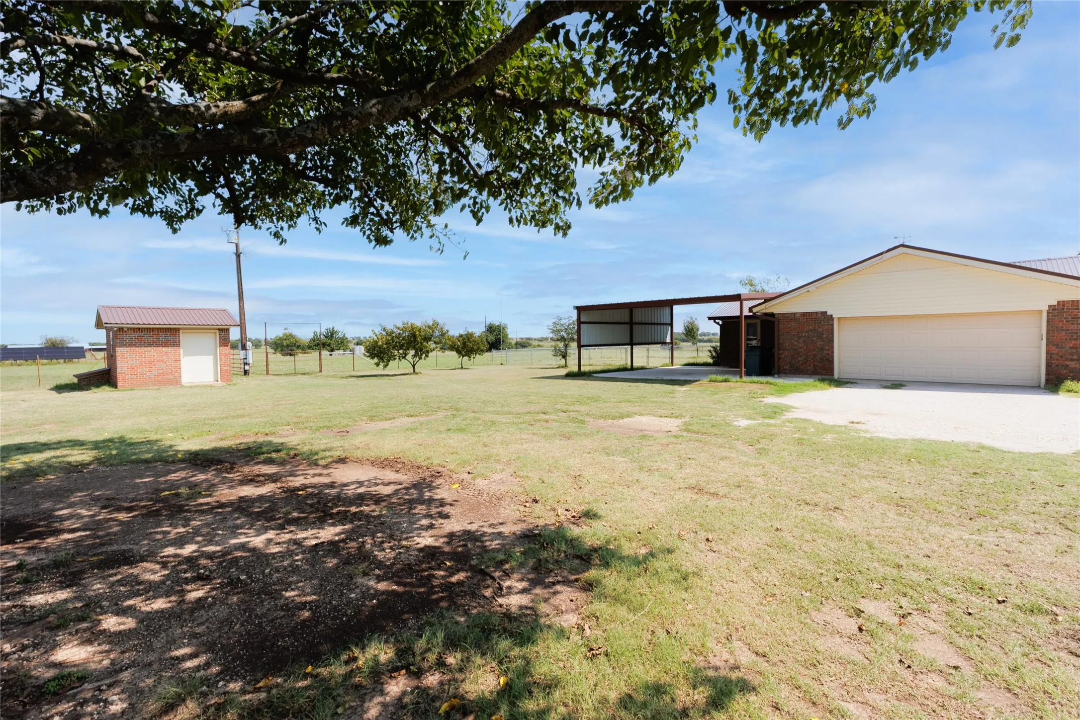 View of grassy yard featuring an outdoor structure and a garage