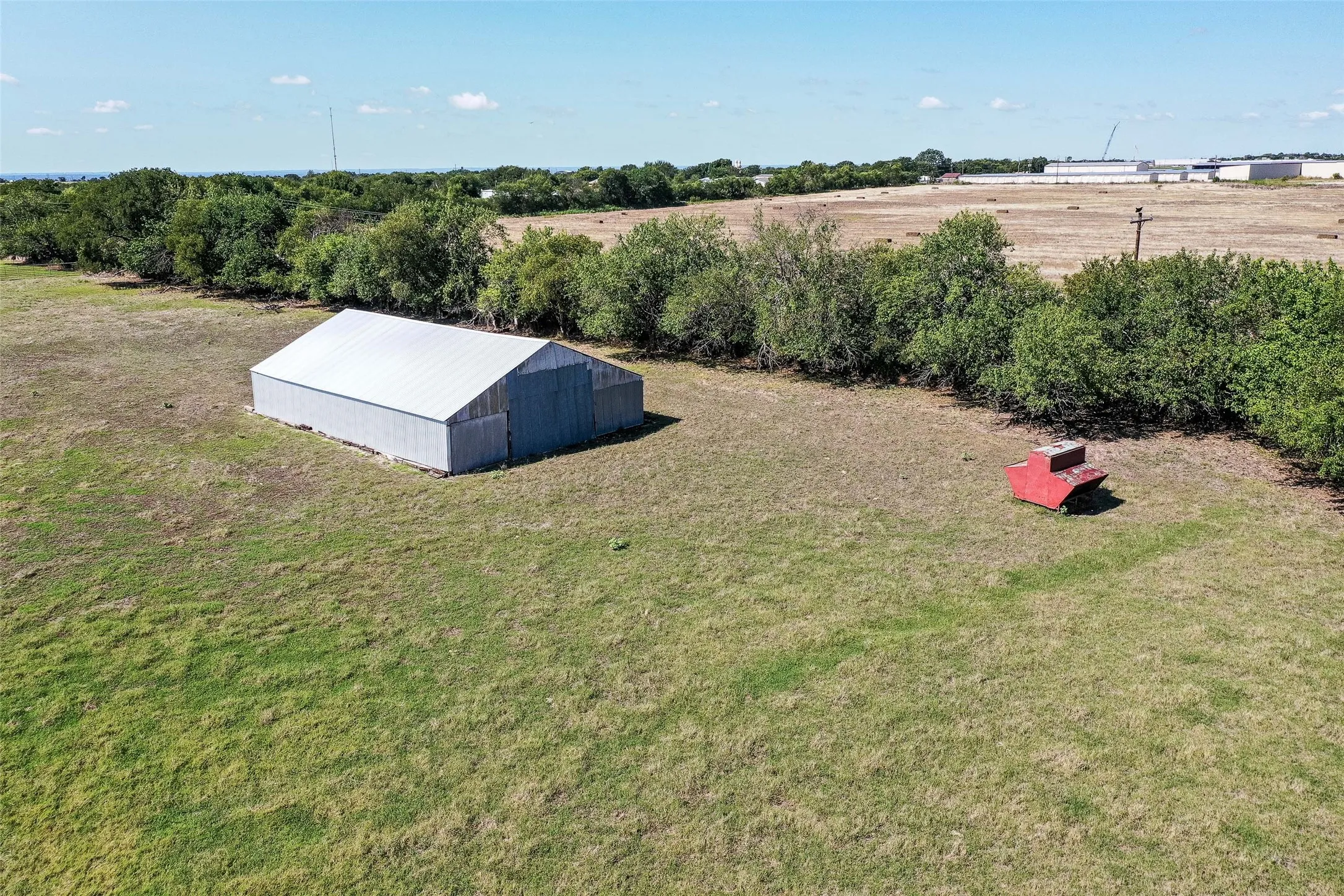 View of grassy yard featuring a pole building, a view of countryside, and an outdoor structure