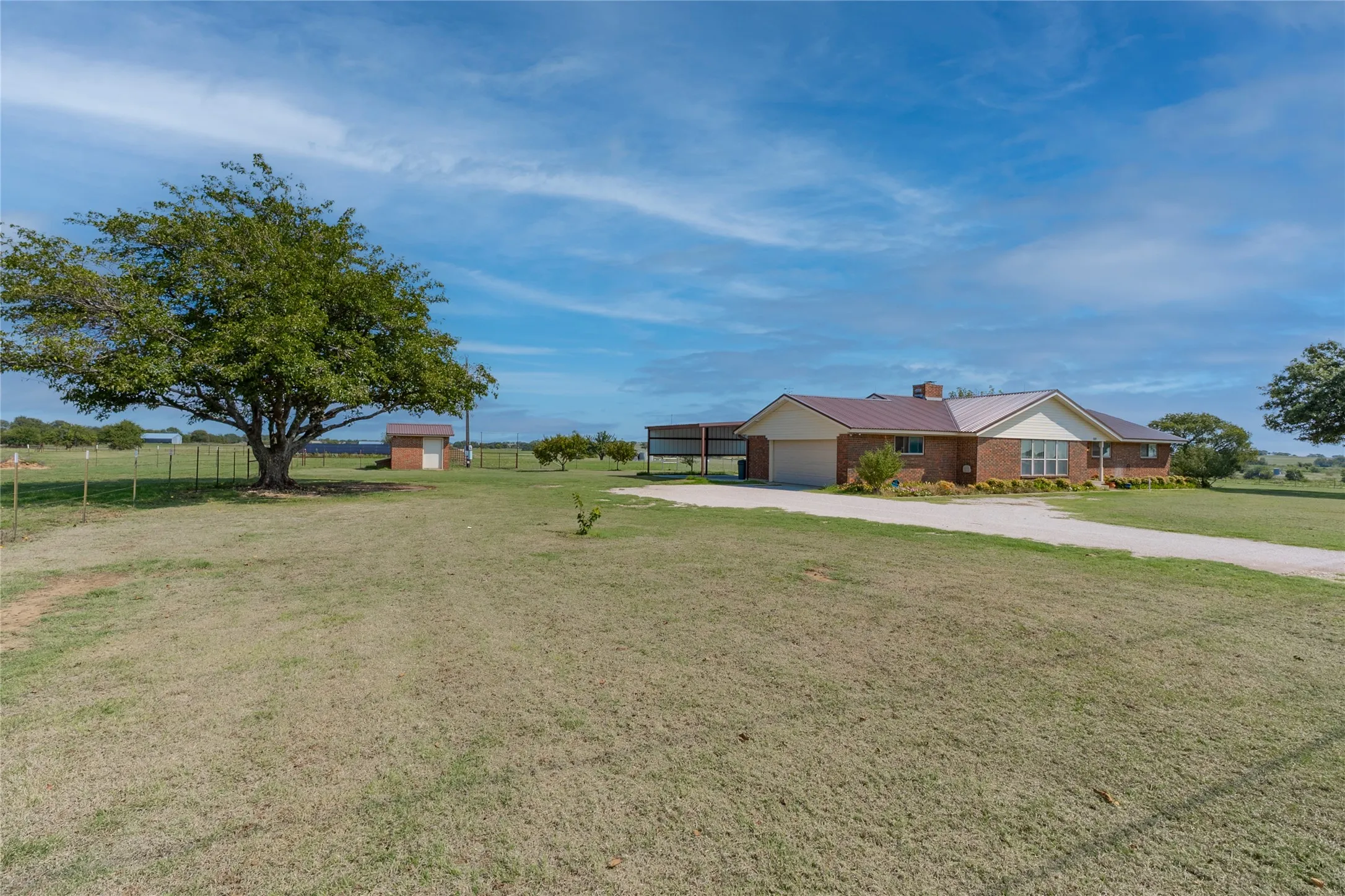 View of yard with a garage, driveway, and a view of countryside