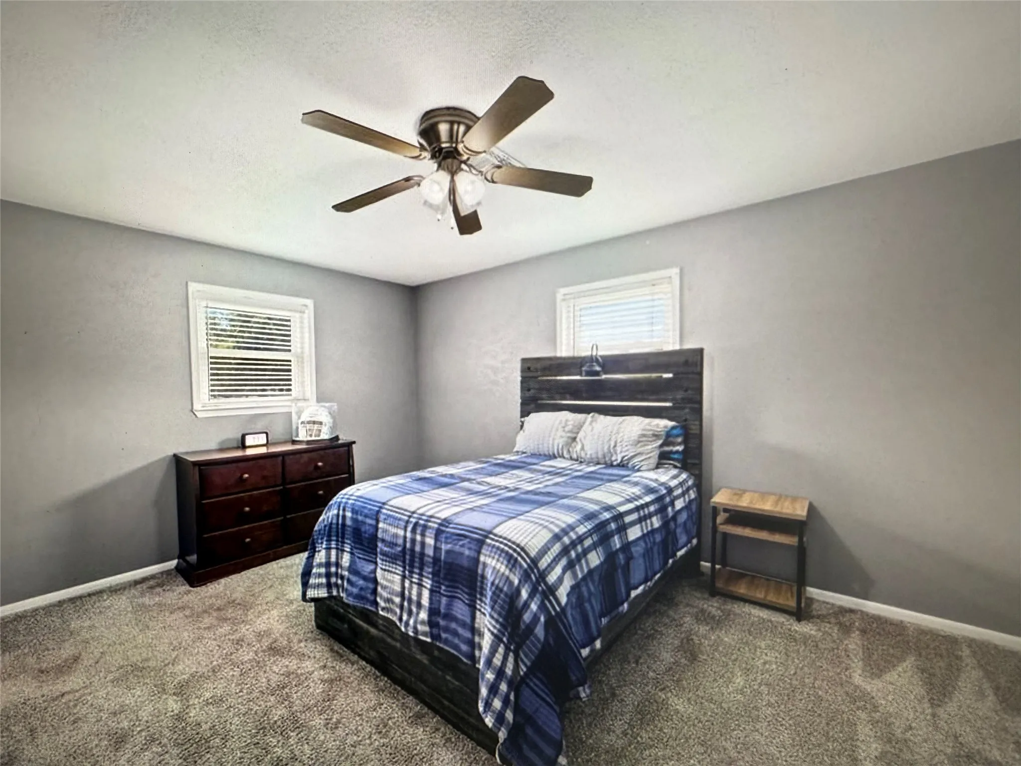 Bedroom with carpet flooring, a ceiling fan, and a textured ceiling