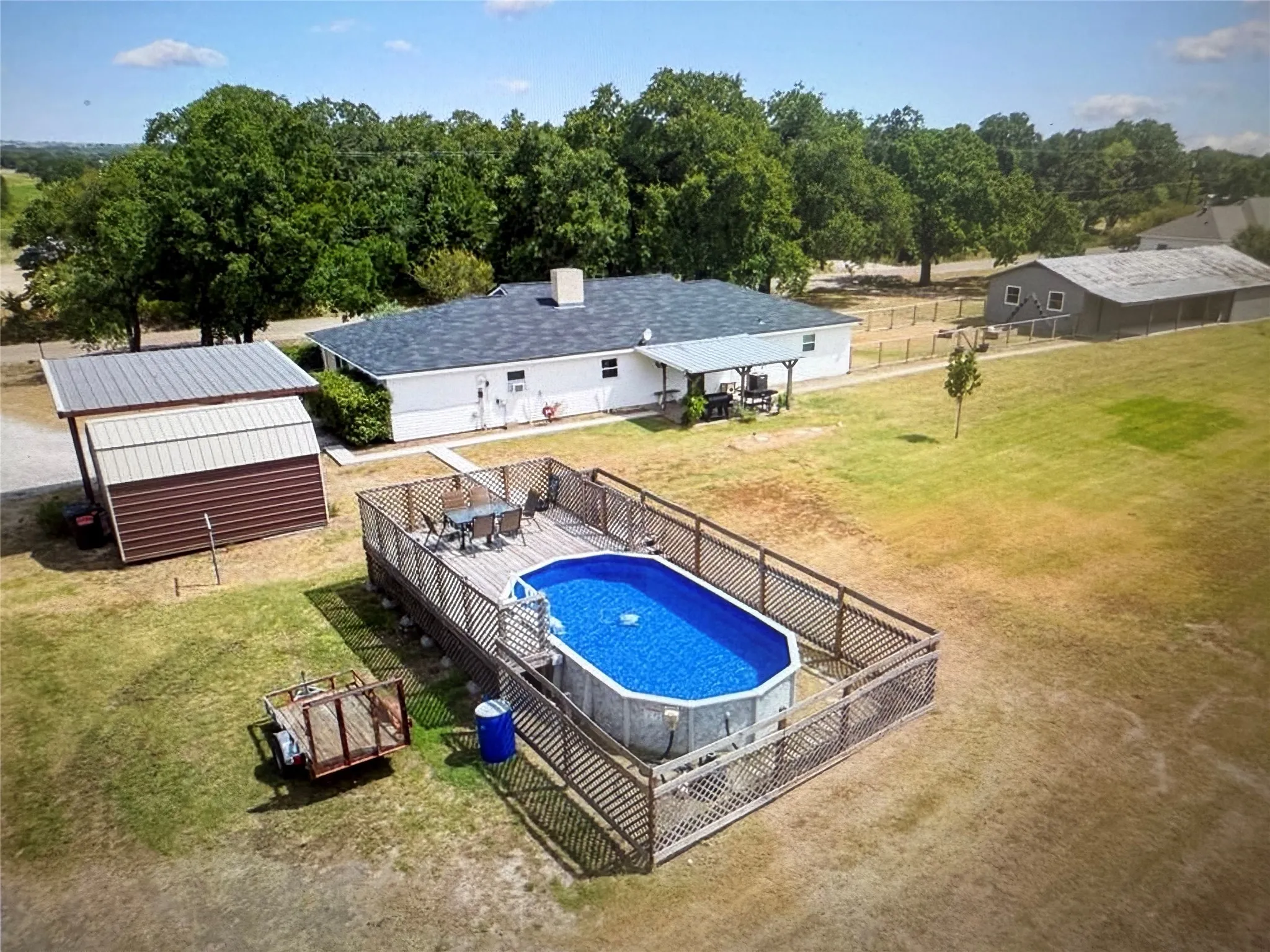 View of swimming pool featuring a deck and an outbuilding